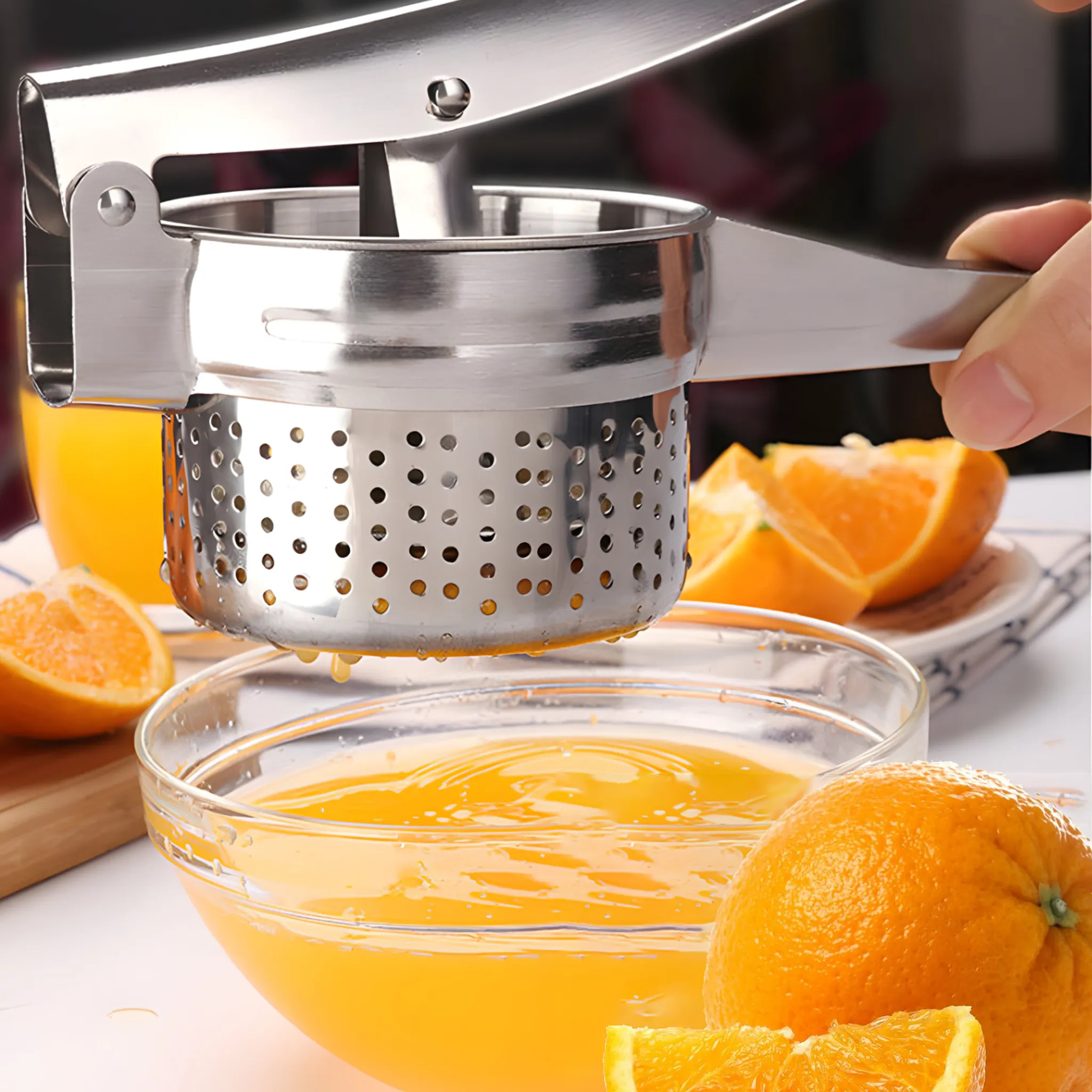 Eine Metallpresse presst Orangensaft in eine Glasschüssel. Orangen und Orangenscheiben umgeben die Schüssel.