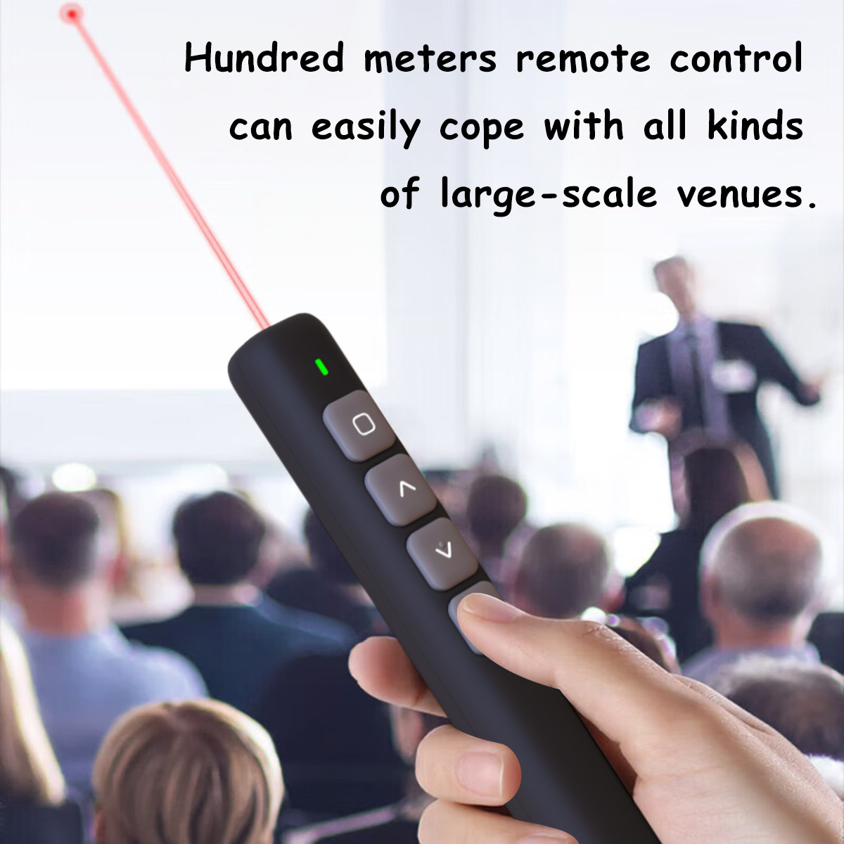 Eine Hand hält eine schwarze Fernbedienung mit rotem Laserpointer. Eine Präsentation findet in einem großen Veranstaltungsort statt.
