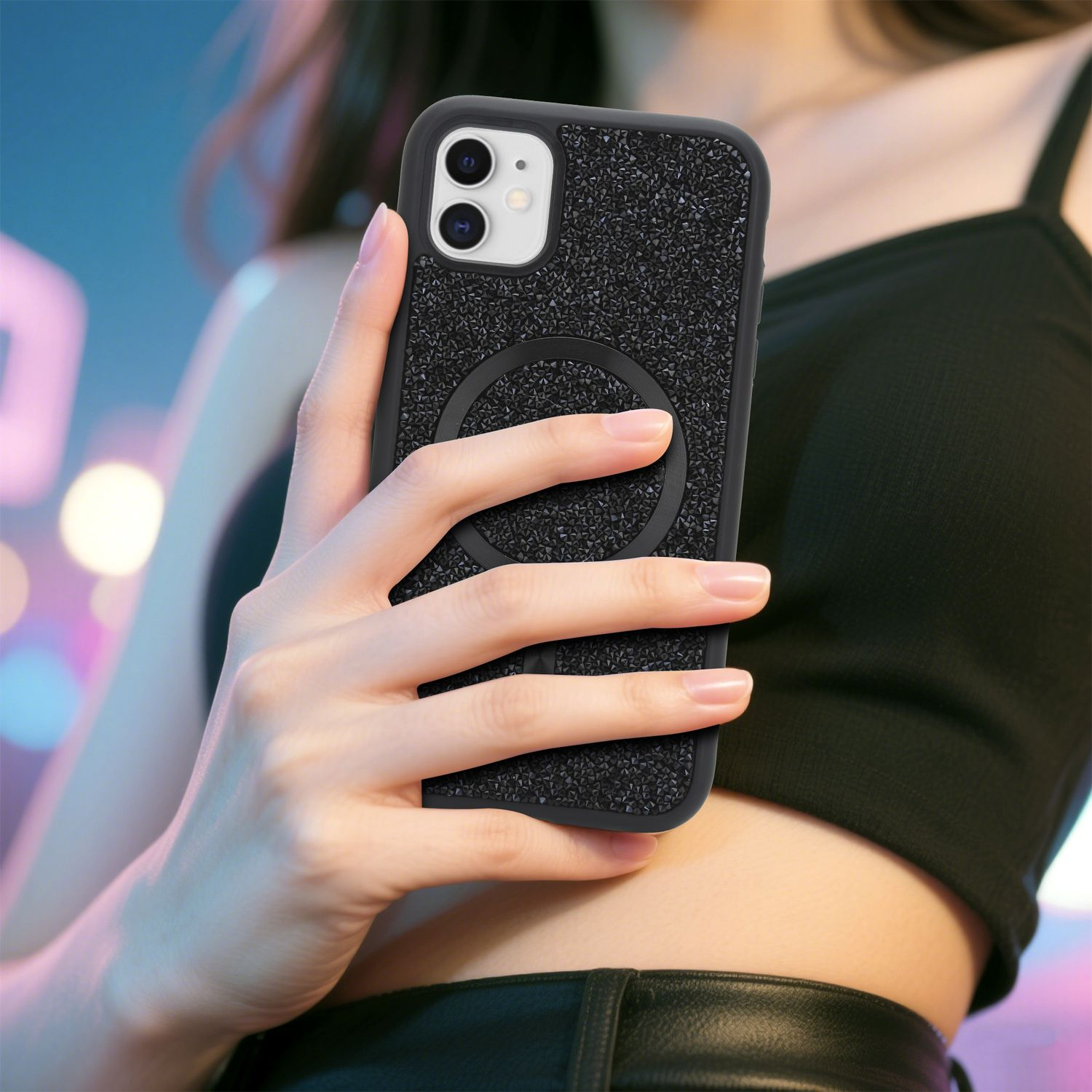 Eine Person hält ein schwarzes Telefon mit strukturierter Hülle. Der Hintergrund ist mit blauen und rosa Farbtönen verschwommen. Die Person trägt Schwarz.