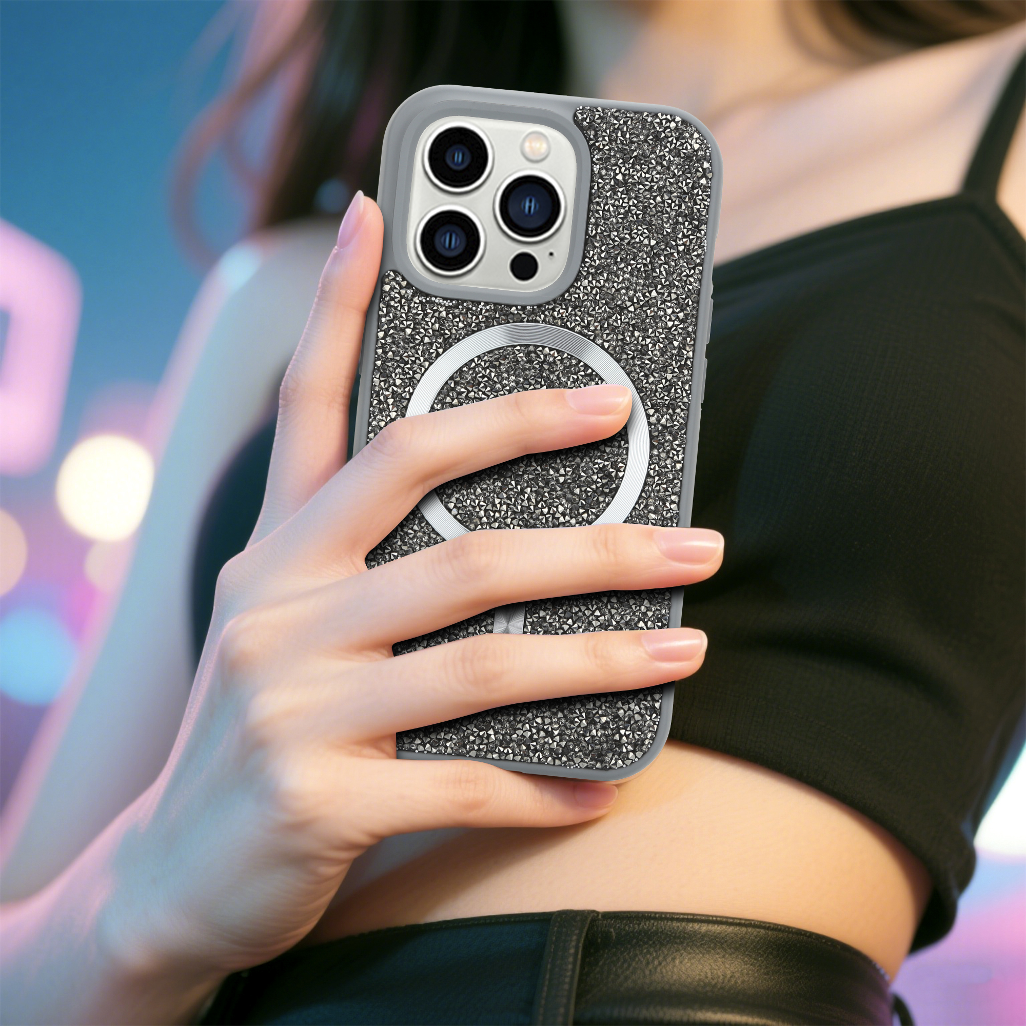 Eine Frau hält ein Telefon in einer glitzernden Hülle. Das Telefon hat drei Kameras. Der Hintergrund ist mit blauen und rosa Lichtern verschwommen.