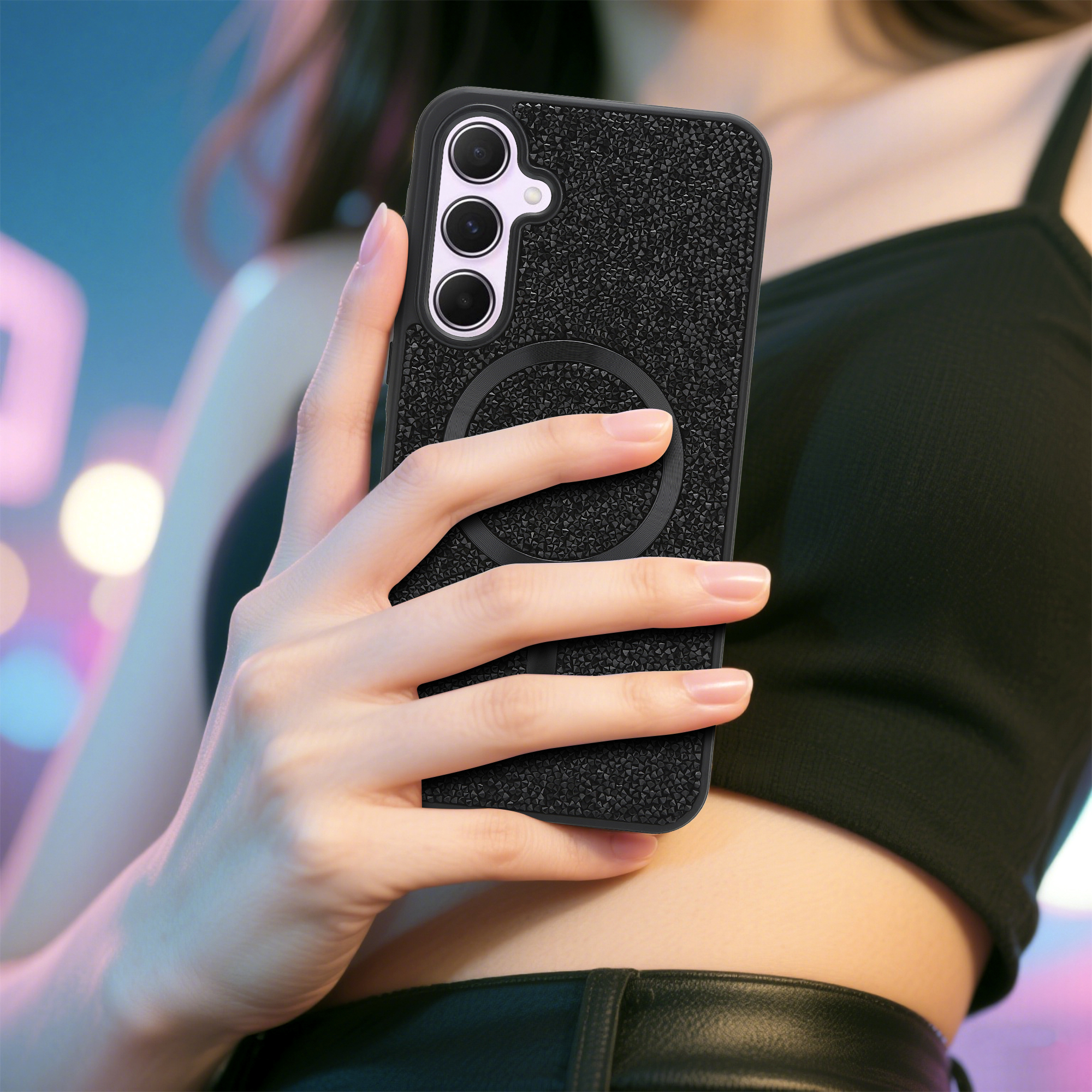 Eine Person hält eine schwarze Handyhülle mit einem Kreis. Die Hülle befindet sich auf einem Telefon mit drei Kameras.