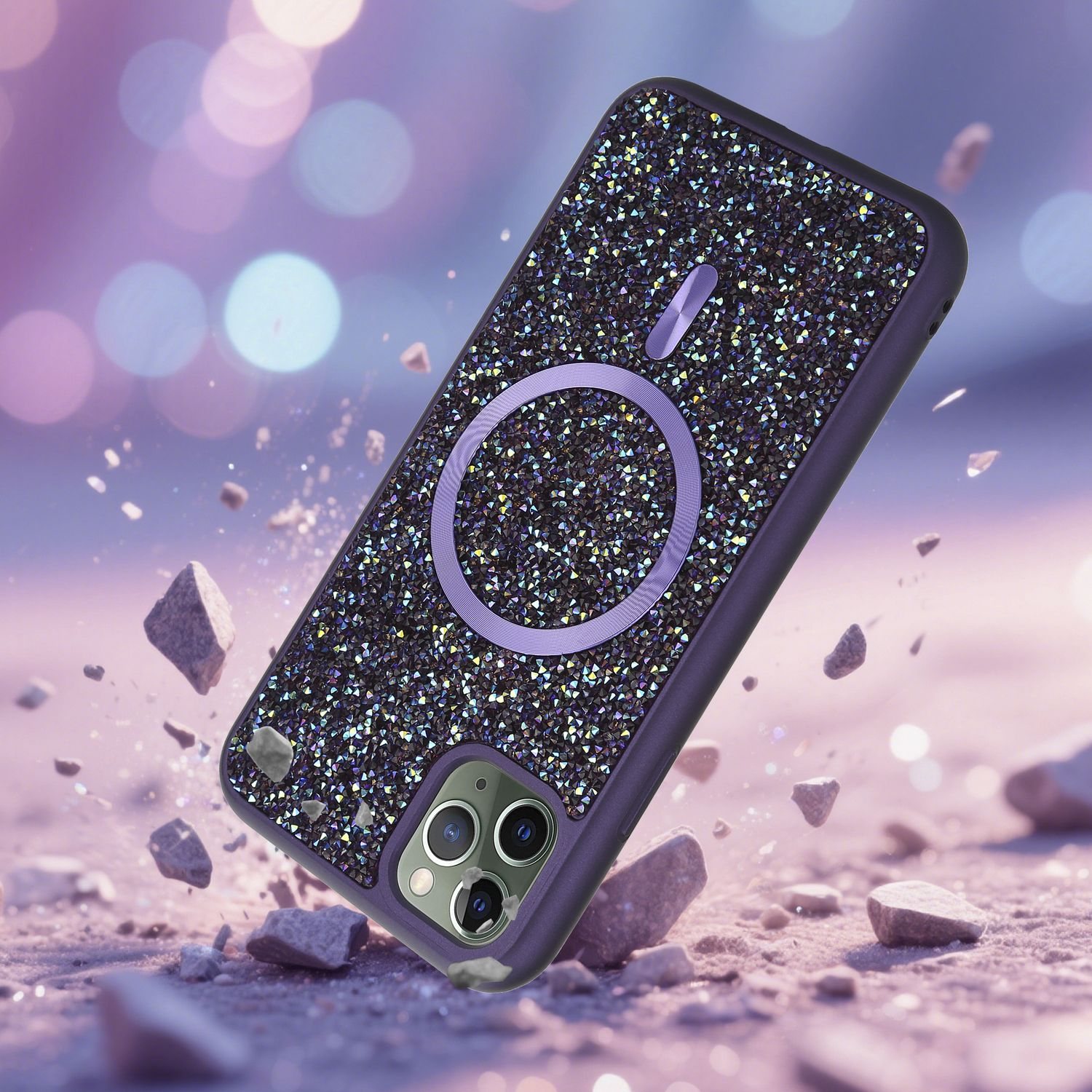 Eine lila Handyhülle mit funkelnden Kristallen und einem kreisförmigen MagSafe-Design, die mit Trümmern vor einem Bokeh-Hintergrund fällt.