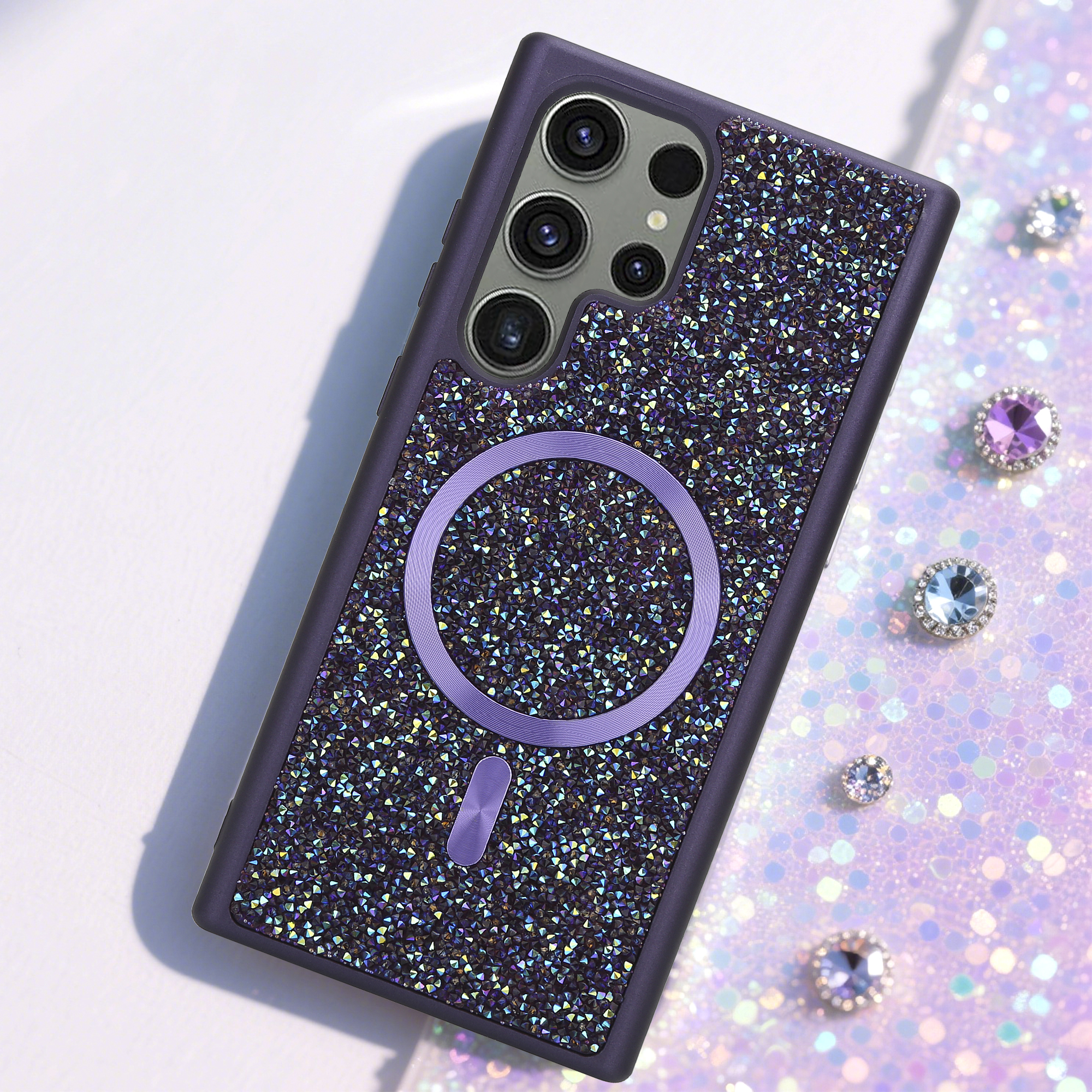 Lila Handyhülle mit glitzernden Details. Strasssteine und ein lila Kreis sind sichtbar. Weißer Hintergrund.