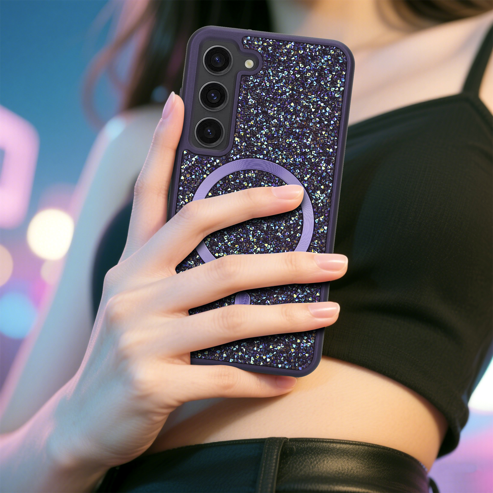 Eine Hand hält eine verzierte Handyhülle. Das Telefon hat drei Kameras. Der Hintergrund ist mit Neonfarben verschwommen.