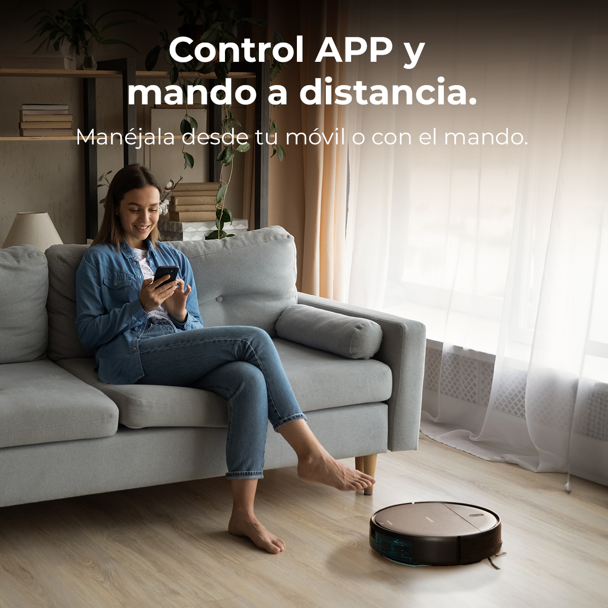 Kobieta na kanapie używa telefonu. Na podłodze znajduje się odkurzacz automatyczny. Tekst głosi: 'Sterowanie APLIKACJĄ i pilotem'.
