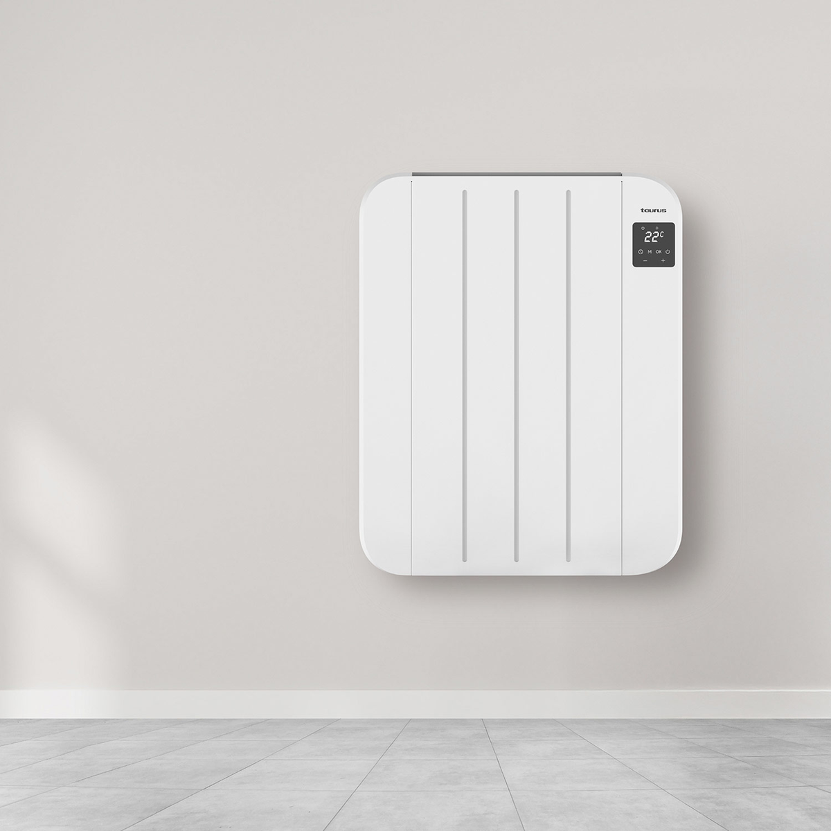 Un riscaldatore bianco a parete con display digitale che mostra 22 gradi. È su una parete grigia sopra un pavimento piastrellato.