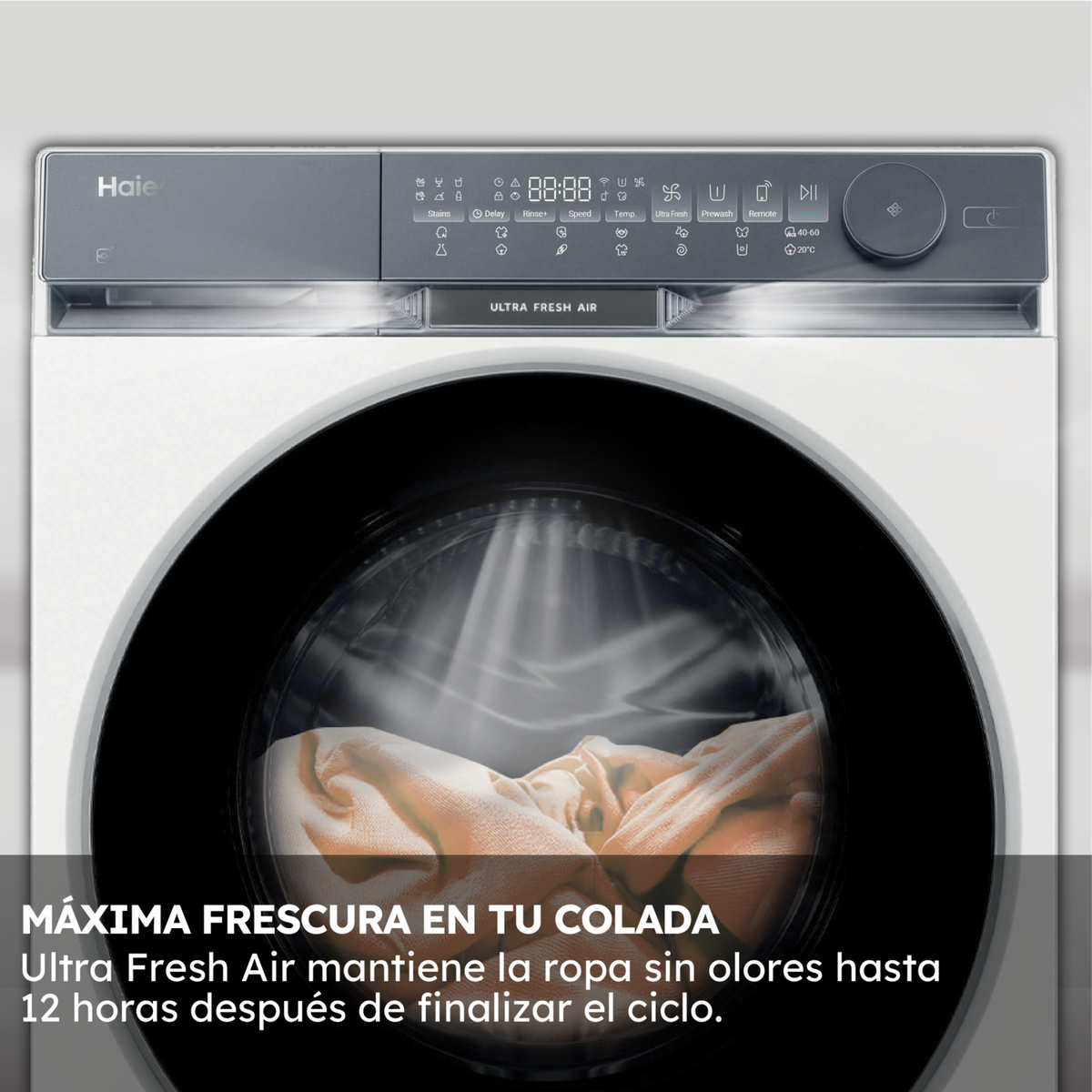 Una lavadora Haier blanca. En el interior, se ven prendas de ropa y el panel de control muestra ajustes.