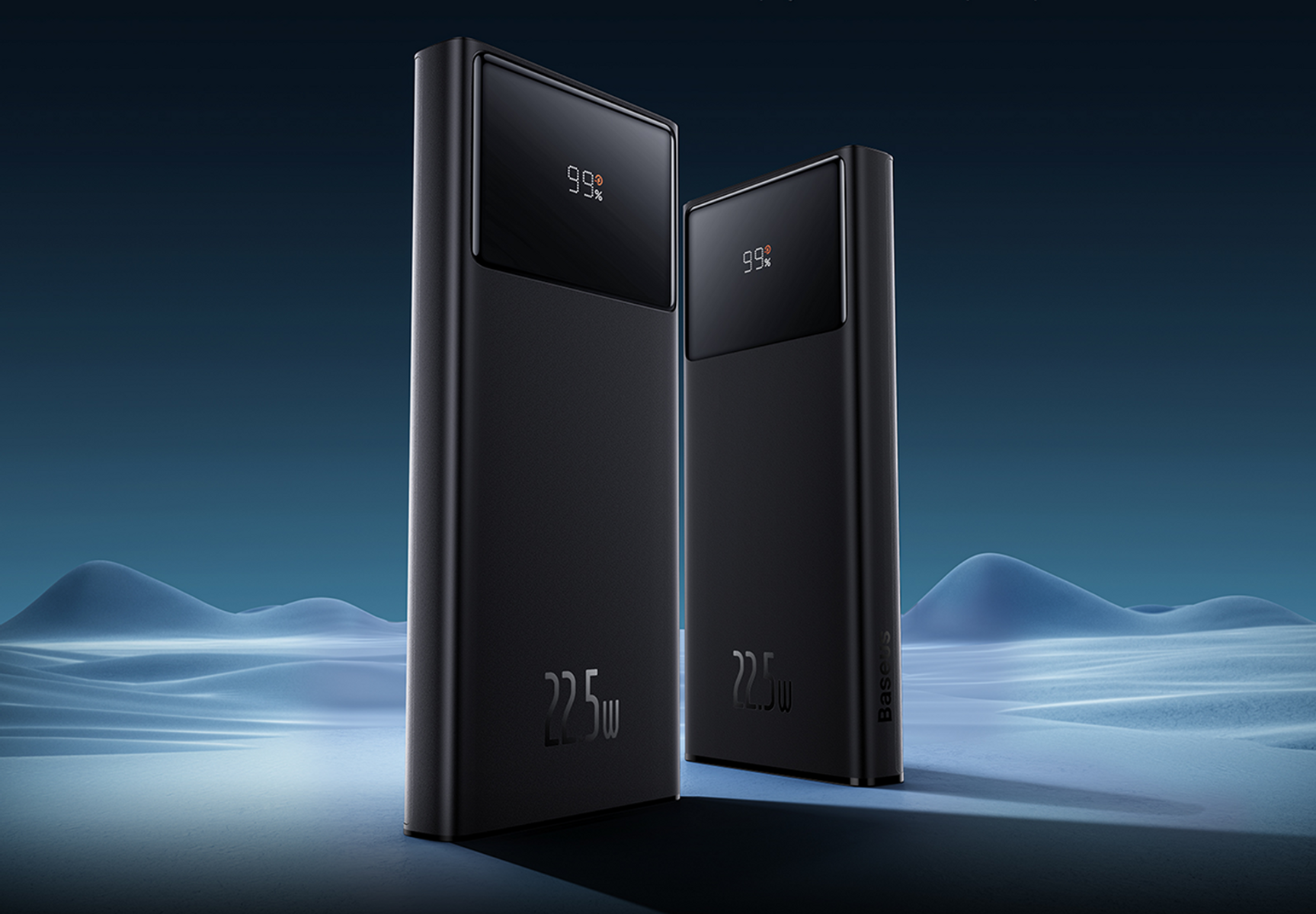 Due power bank neri con display digitali che mostrano il 99%. Lo sfondo presenta un paesaggio innevato con sfumature blu.