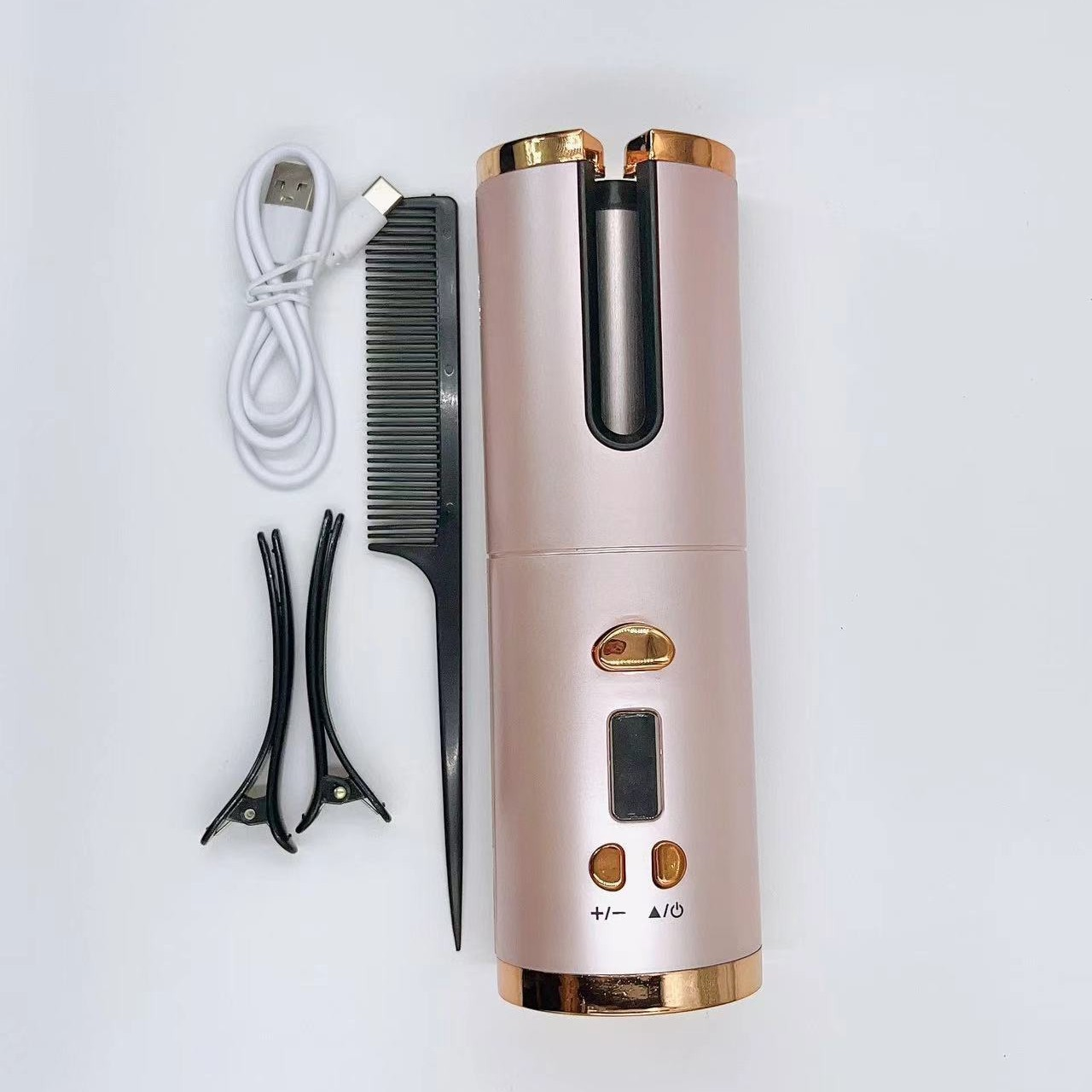 Een roségouden automatische krultang met accessoires: kam, clips en oplaadkabel, tegen een witte achtergrond.