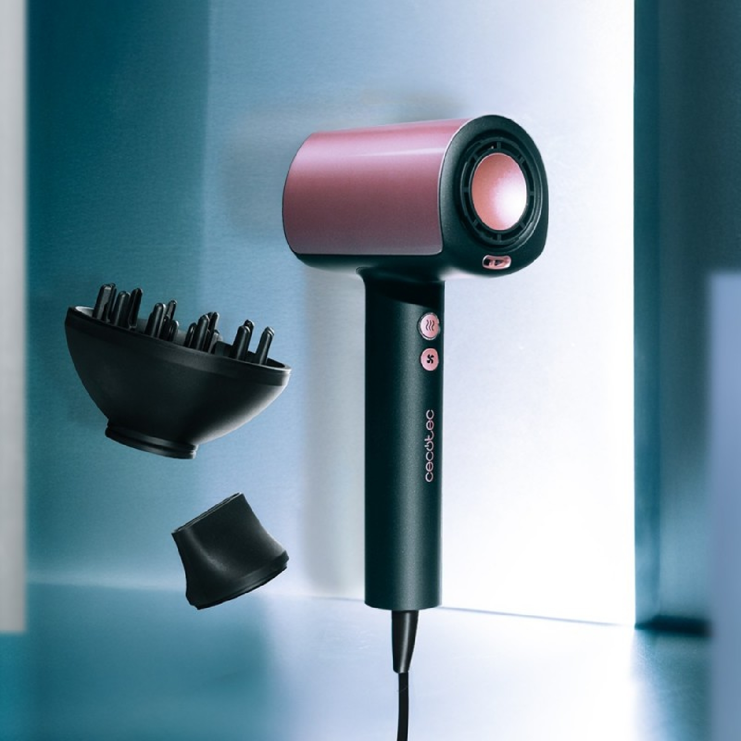 Een haardroger met opzetstukken. Het is roze en zwart. De opzetstukken zijn een diffuser en een mondstuk. Blauwe en witte achtergrond.