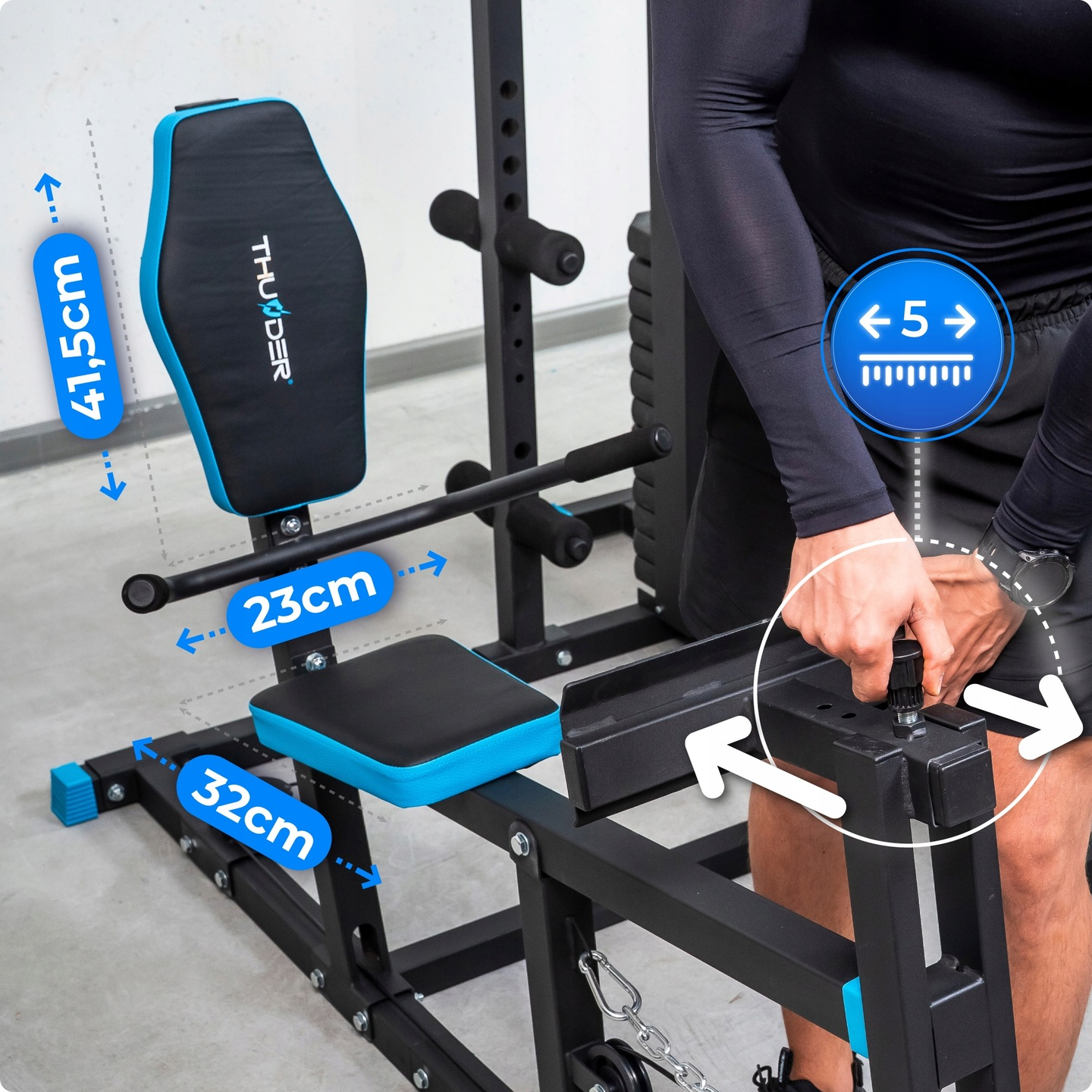 Widać ławkę do ćwiczeń z wymiarami. Osoba reguluje śrubę na ławce. Ławka ma czarne i niebieskie akcenty.