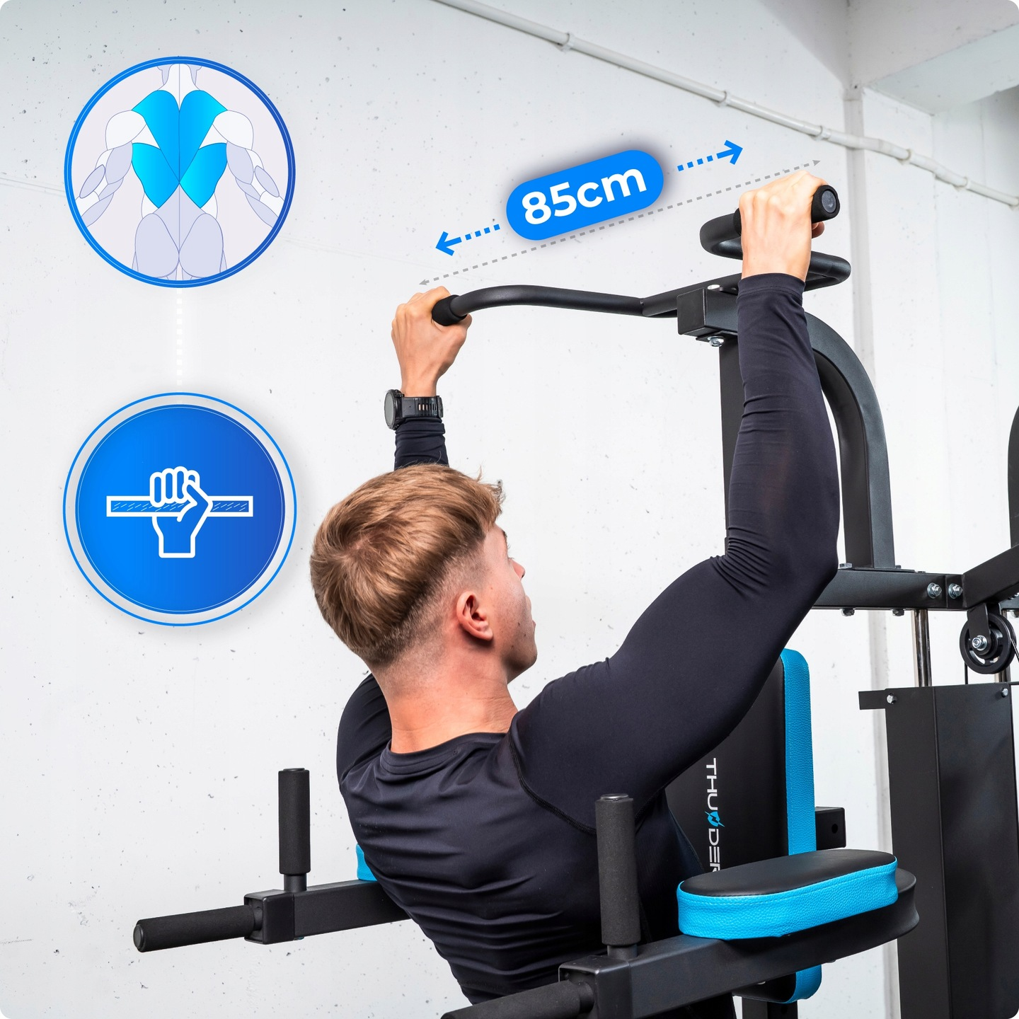 Mężczyzna robi podciągnięcia na czarnym urządzeniu do ćwiczeń. Schematy ilustrują grupy mięśni. Maszyna ma niebieskie akcenty. Pokazana jest etykieta 85 cm.