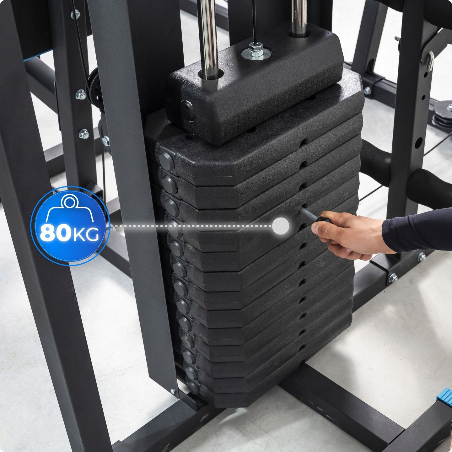 Osoba wybiera ciężary na maszynie do ćwiczeń. Czarne ciężary są ułożone w stos. Rama maszyny jest czarna. Widoczna jest etykieta 80 kg.