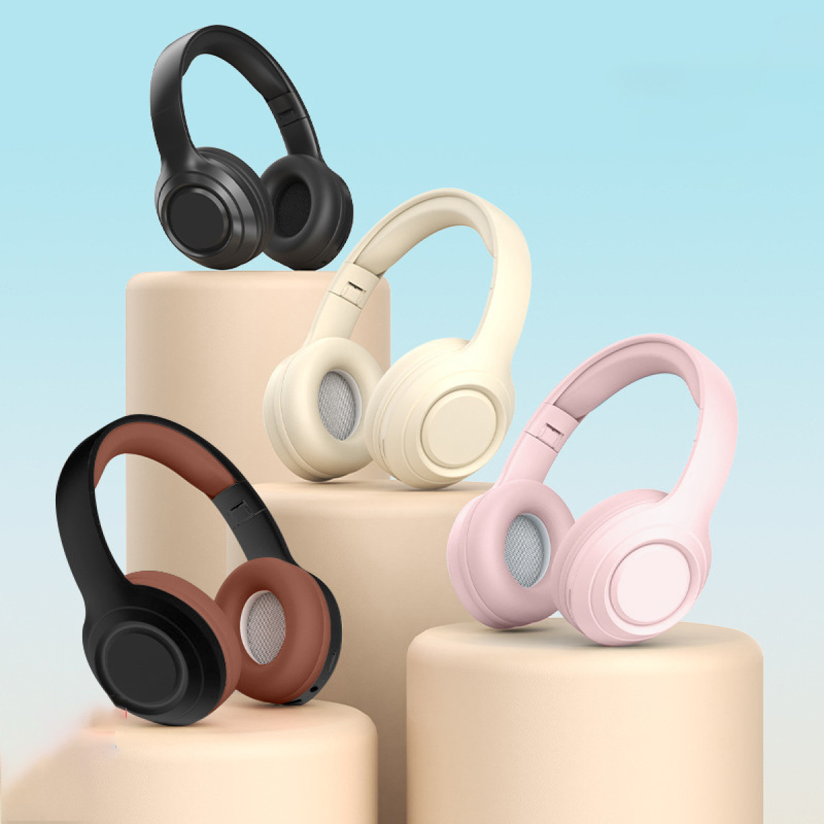 Vier bunte Kopfhörer auf Podesten vor einem blau-weißen Hintergrund. Farben: Schwarz, Beige, Rosa und Braun.