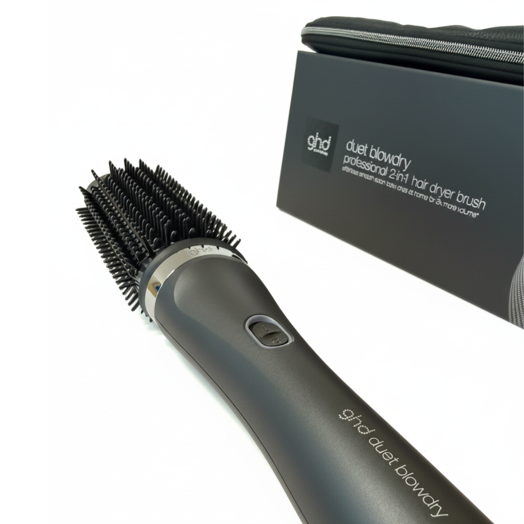 Un asciugacapelli ghd duet blowdry professionale 2 in 1. È nero e ha una testina a spazzola. Una scatola e una custodia nere sono sullo sfondo.