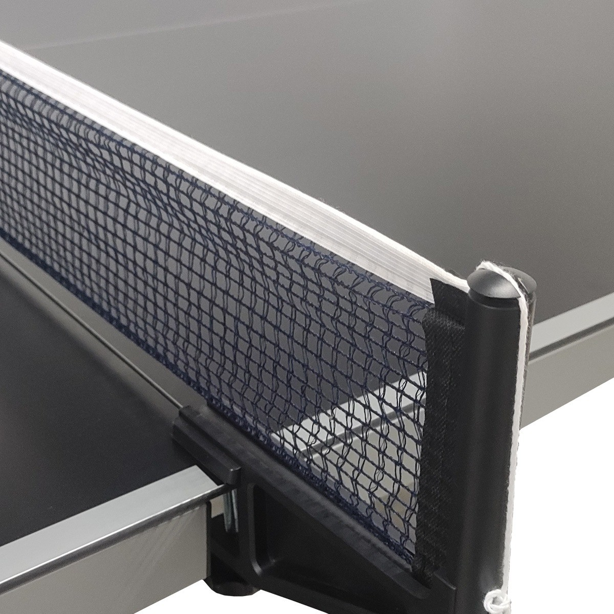 Close-up of a ping pong table net. The net is dark blue, with a black post and a white string. The table is black.