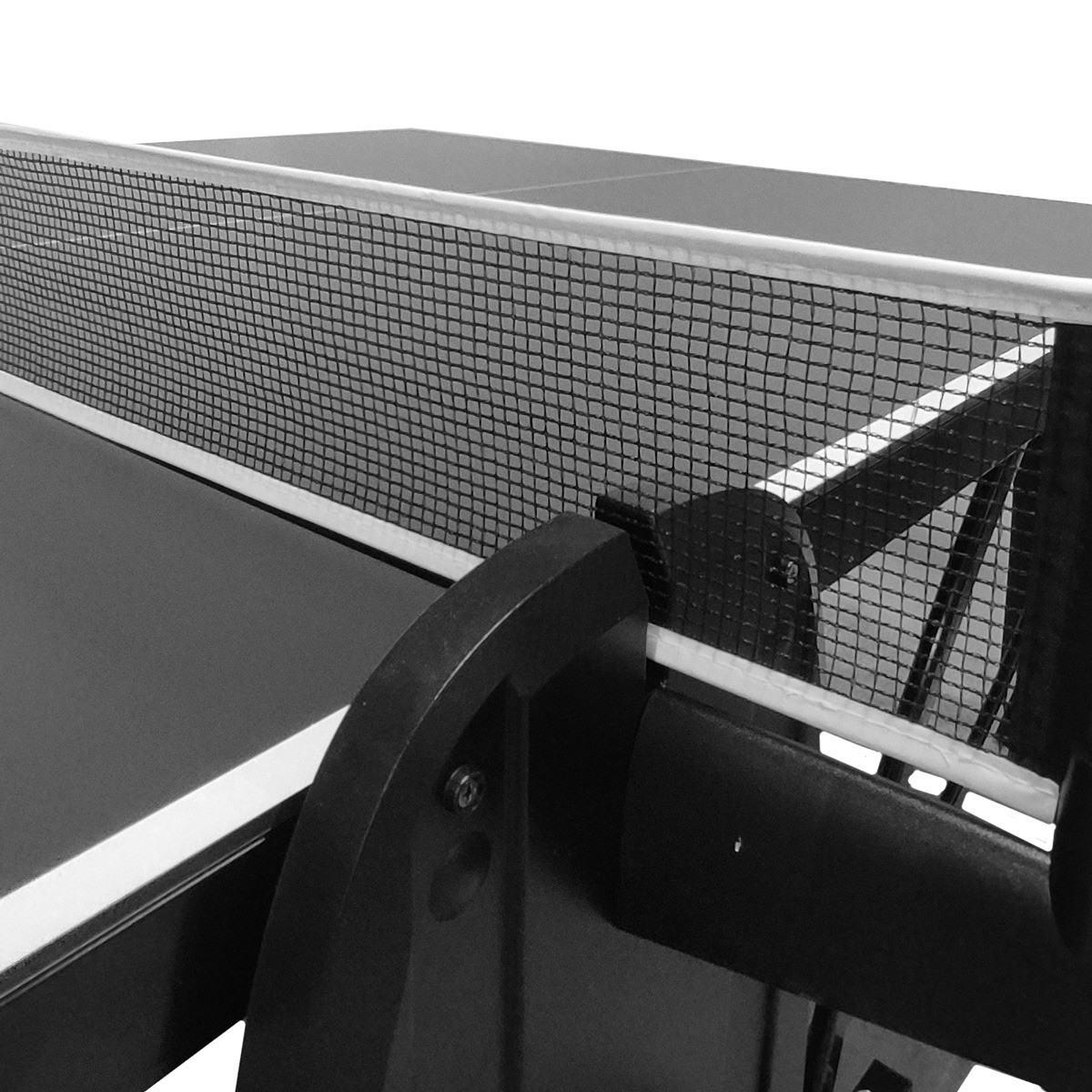 Close-up of a ping pong table net. The net is black and white, with a dark table surface and support structure.