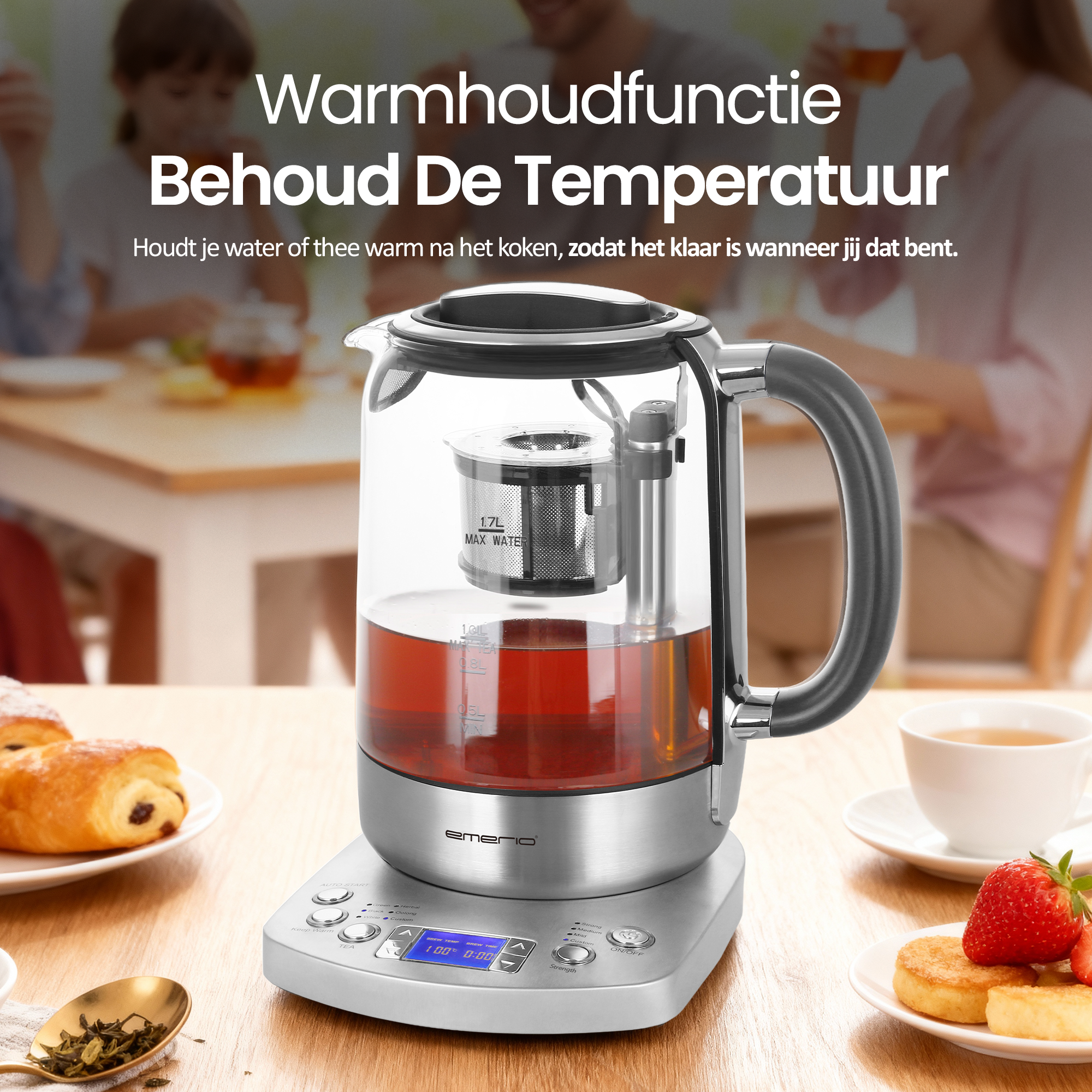 Een glazen theepot op een zilveren voet, met thee erin. Croissants, theekoekjes en een kopje thee staan op tafel.