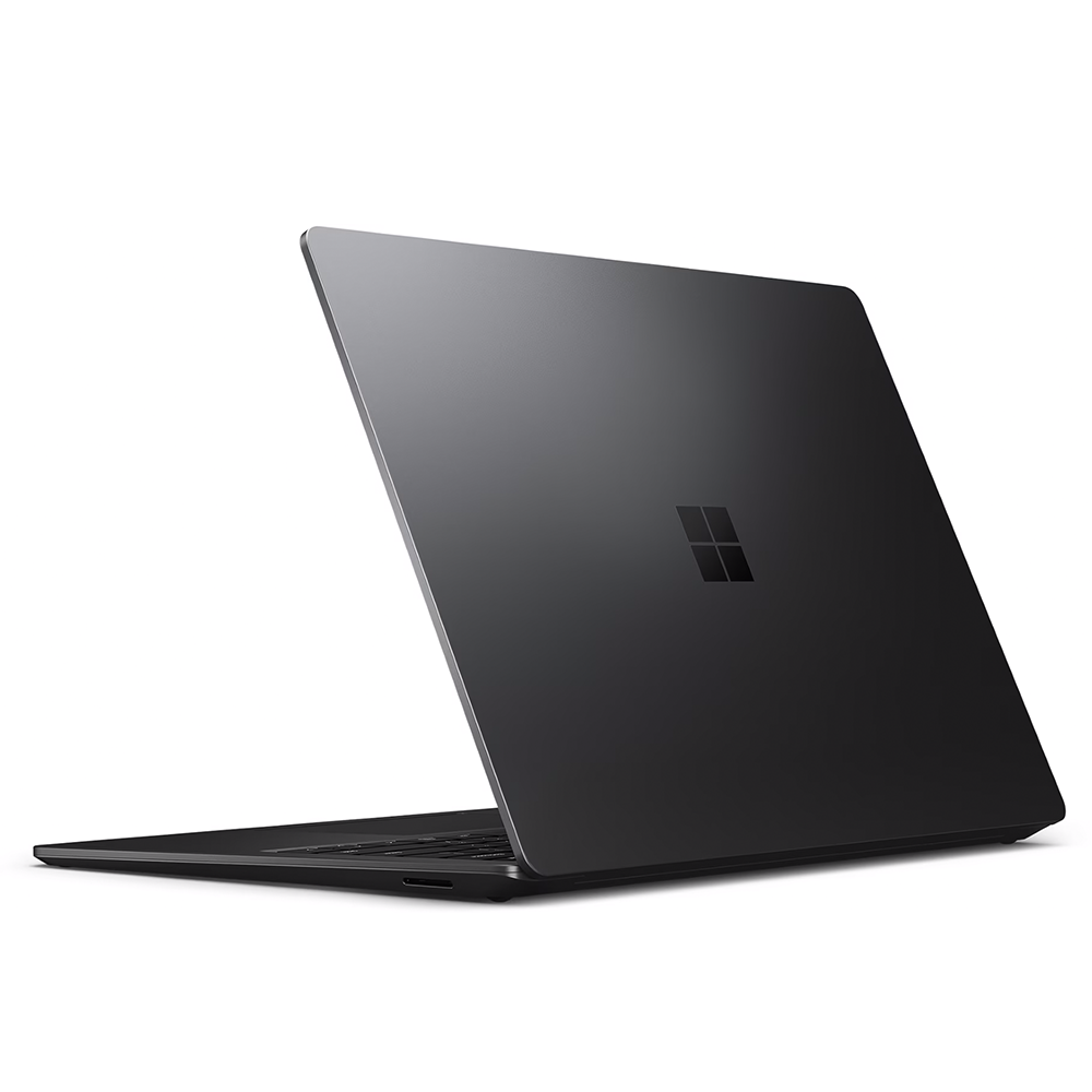 A dark gray laptop is open, showing the back with the Microsoft logo. The screen is angled up, set against a white background.