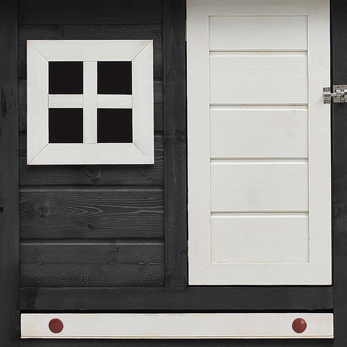 Nahaufnahme einer Holzkonstruktion mit weißem Fenster und Tür. Die Struktur ist in Schwarz und Weiß mit roten Details bemalt.