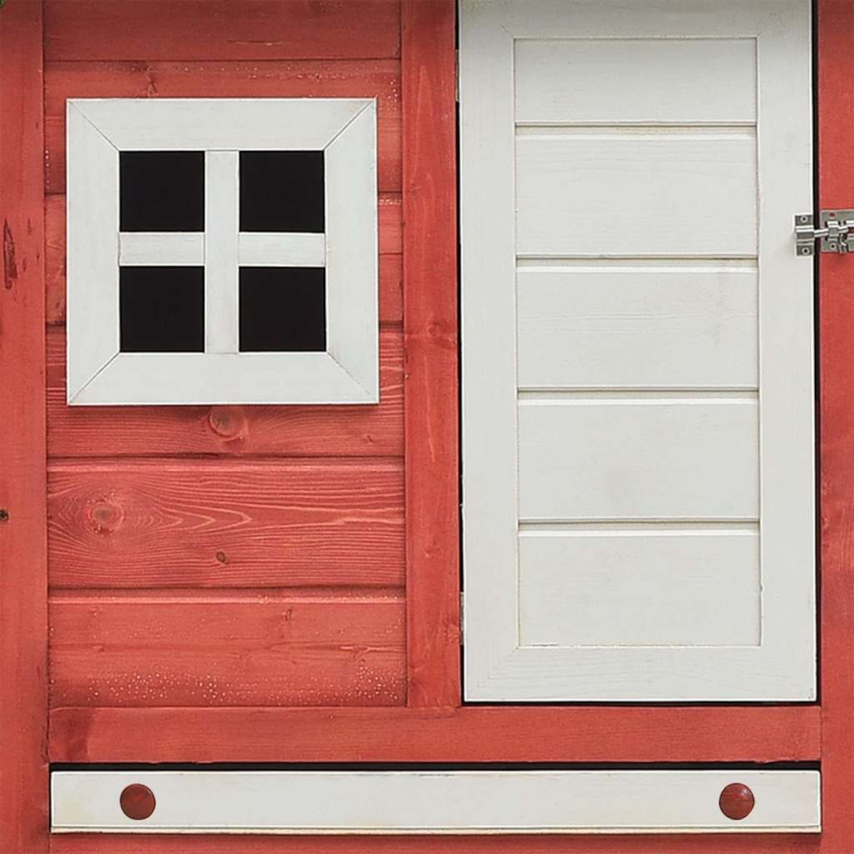 Rotes Holzspielhaus mit weißem Fenster und Tür. Fenster hat Kreuzdesign. Tür hat horizontale Bretter. Zwei rote Knöpfe unten.