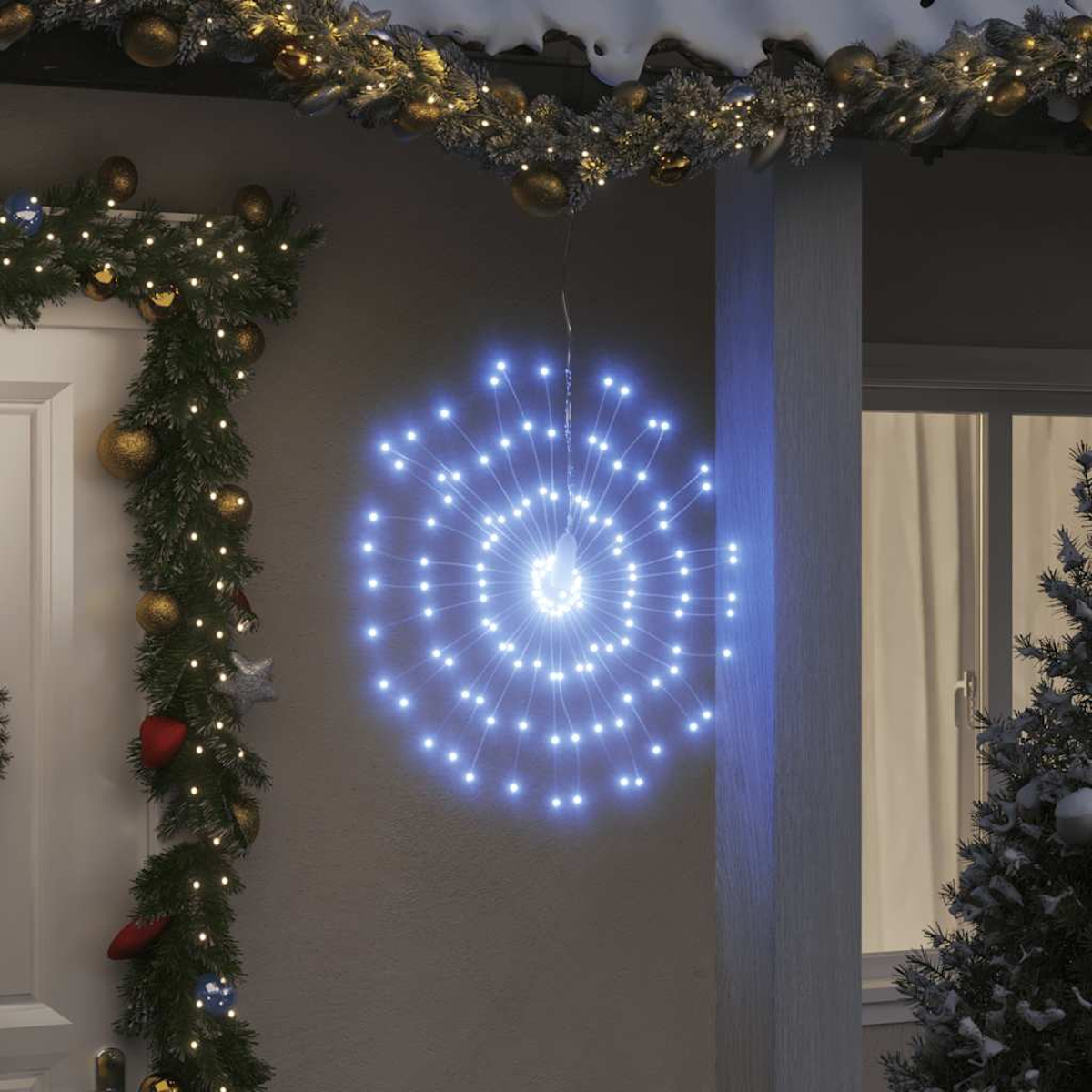 Eine leuchtende blaue Sternschnuppen-Lichtdekoration hängt vor einem Haus, mit Weihnachtsgirlande und einem schneebedeckten Dach.
