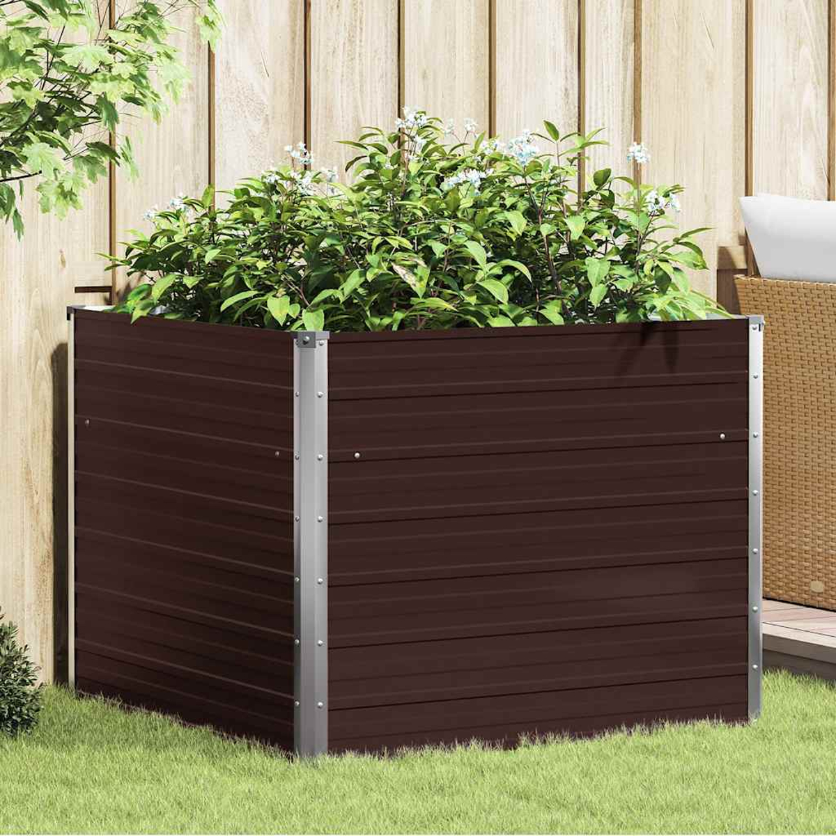 Eine braune Pflanzkasten mit grünen Pflanzen und kleinen weißen Blüten. Die Box hat silberne Metallecken. Es steht auf Gras.
