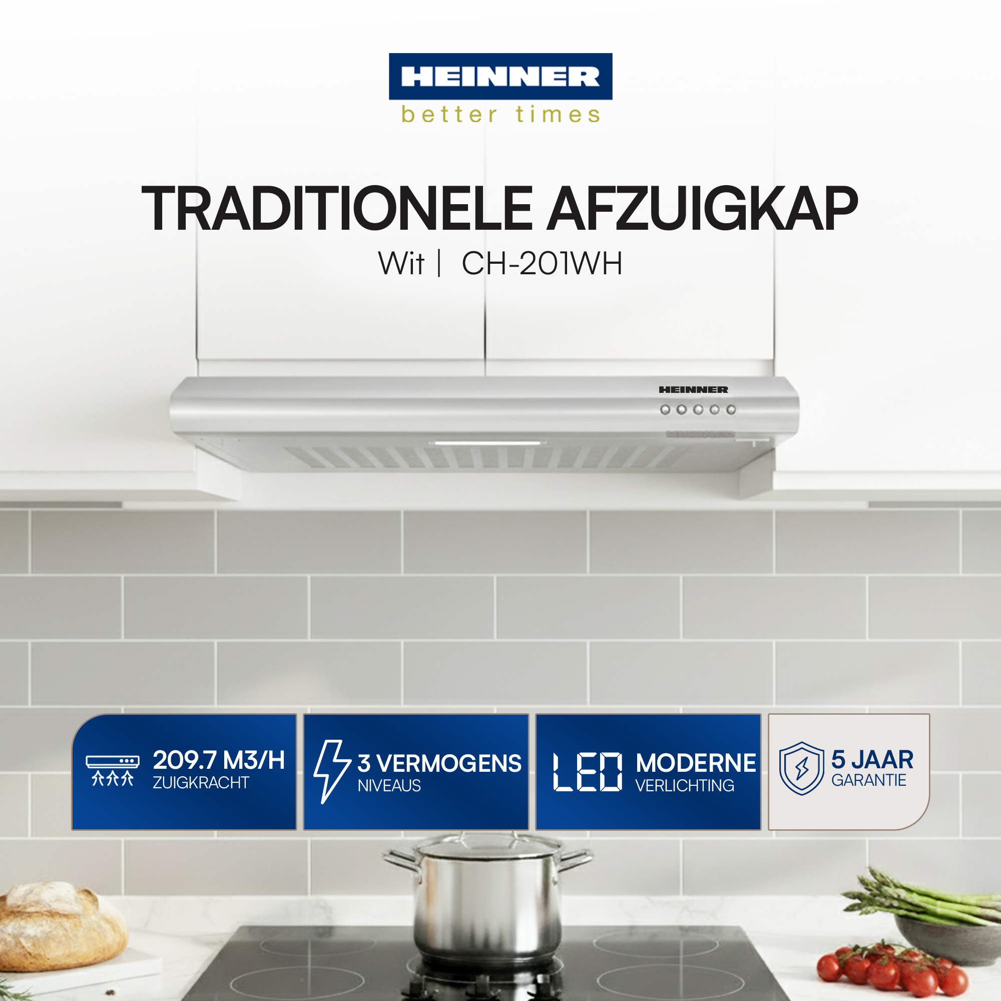 Eine Küchenszene mit einer silbernen Dunstabzugshaube. Darunter ein Topf auf dem Herd, Brot, Tomaten und Spargel.