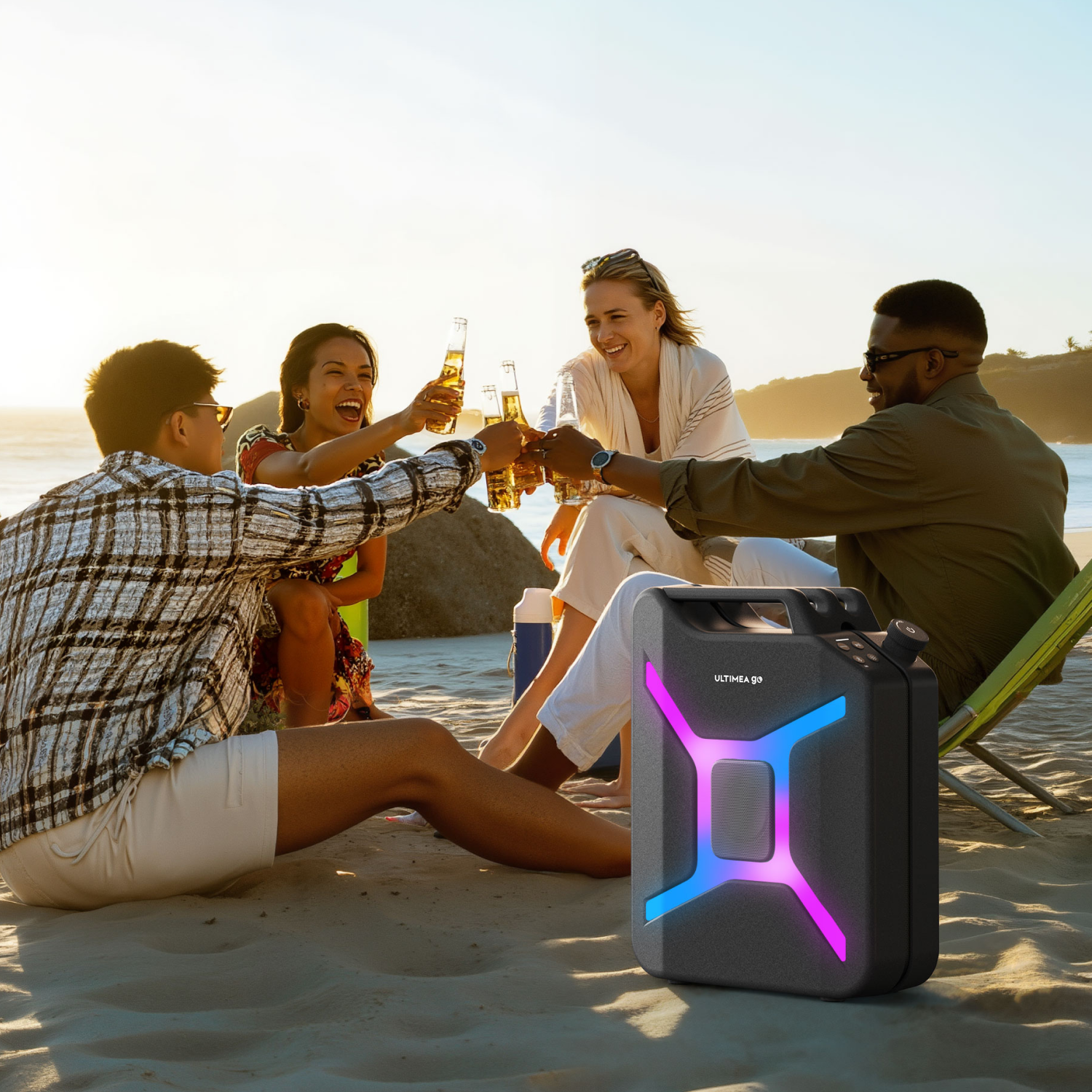 Cztery osoby na plaży wznoszą toasty piwem. Czarny głośnik z niebieskim i różowym światłem jest na pierwszym planie.