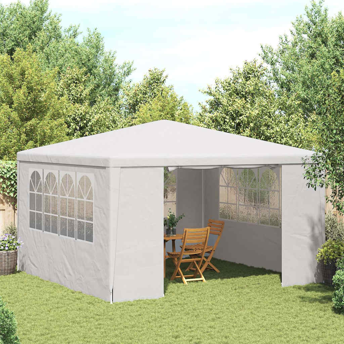 Un gazebo bianco con finestre è allestito su un prato. All'interno, un tavolo e delle sedie sono disposti. Alberi sullo sfondo.