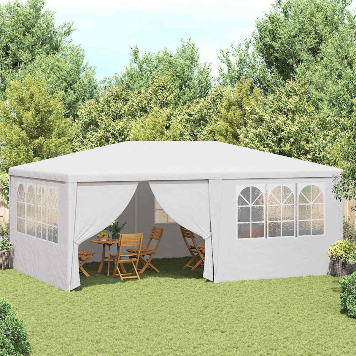 Tenda bianca in giardino. All'interno, tavolo e sedie. Alberi sullo sfondo, il terreno è coperto d'erba.