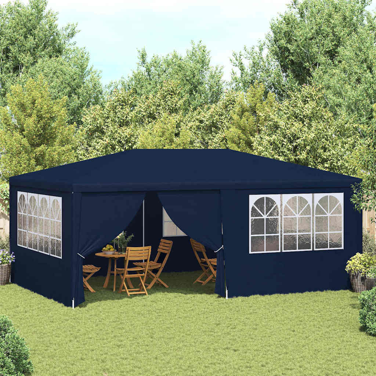 Gazebo blu navy su erba verde, con tavolo e sedie all'interno. Alberi sullo sfondo, vasi di fiori ai lati.