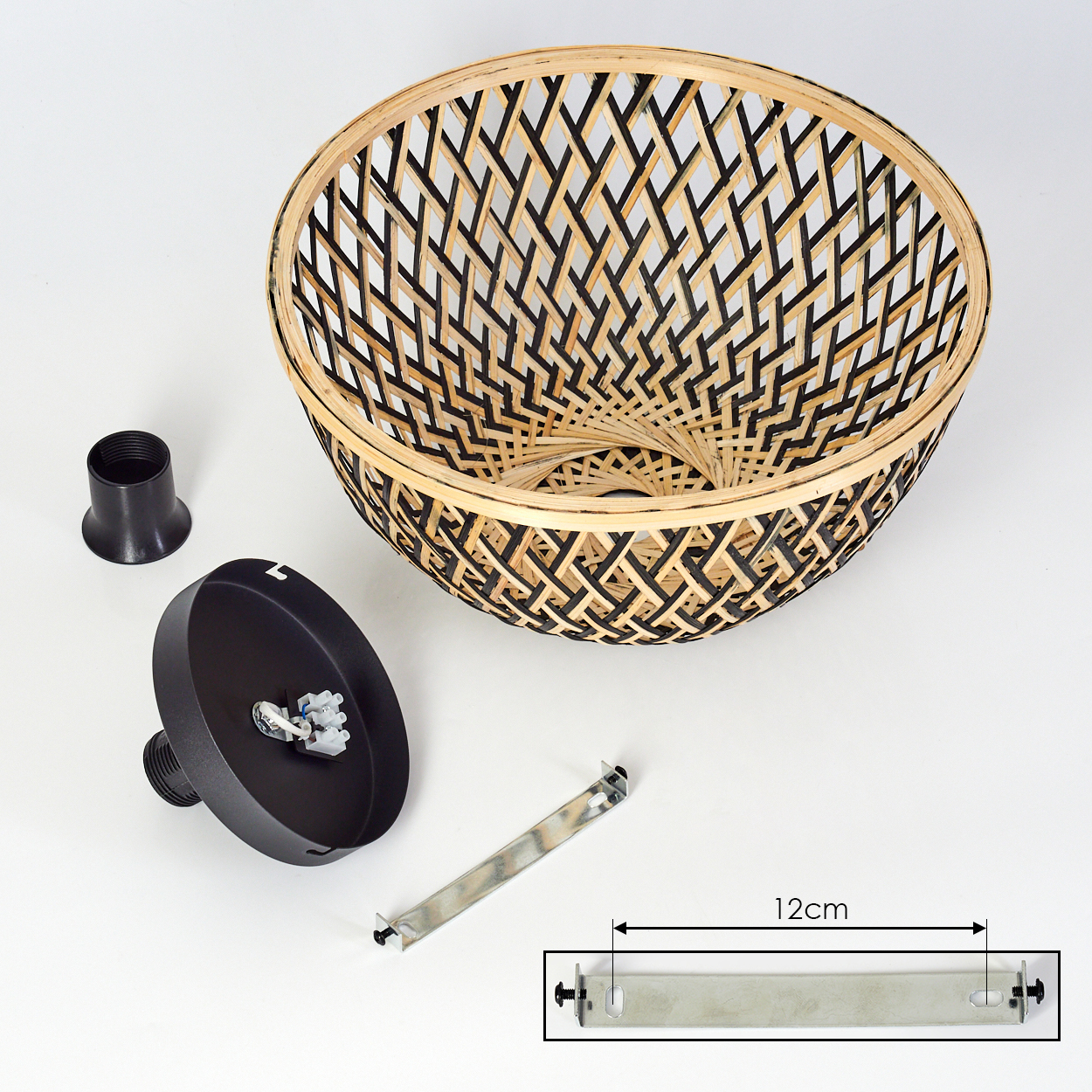 Eine zerlegte Lampe. Ein gewebter Lampenschirm befindet sich über den Teilen: einem schwarzen Sockel, einer schwarzen Fassung und einer Metallhalterung. Eine 12 cm Linie ist angegeben.
