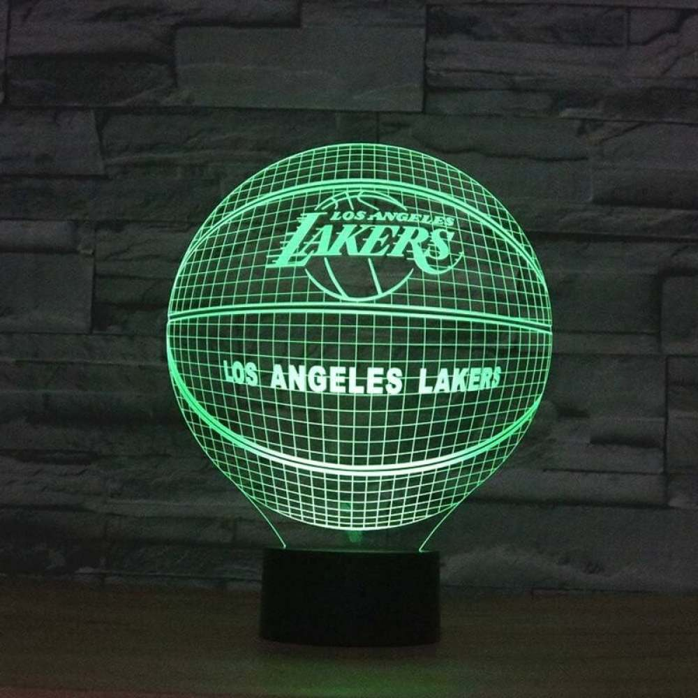 Eine grüne Neon-Basketballlampe der Los Angeles Lakers. Sie hat einen schwarzen Sockel und steht auf einer Holzoberfläche vor einer Backsteinmauer.