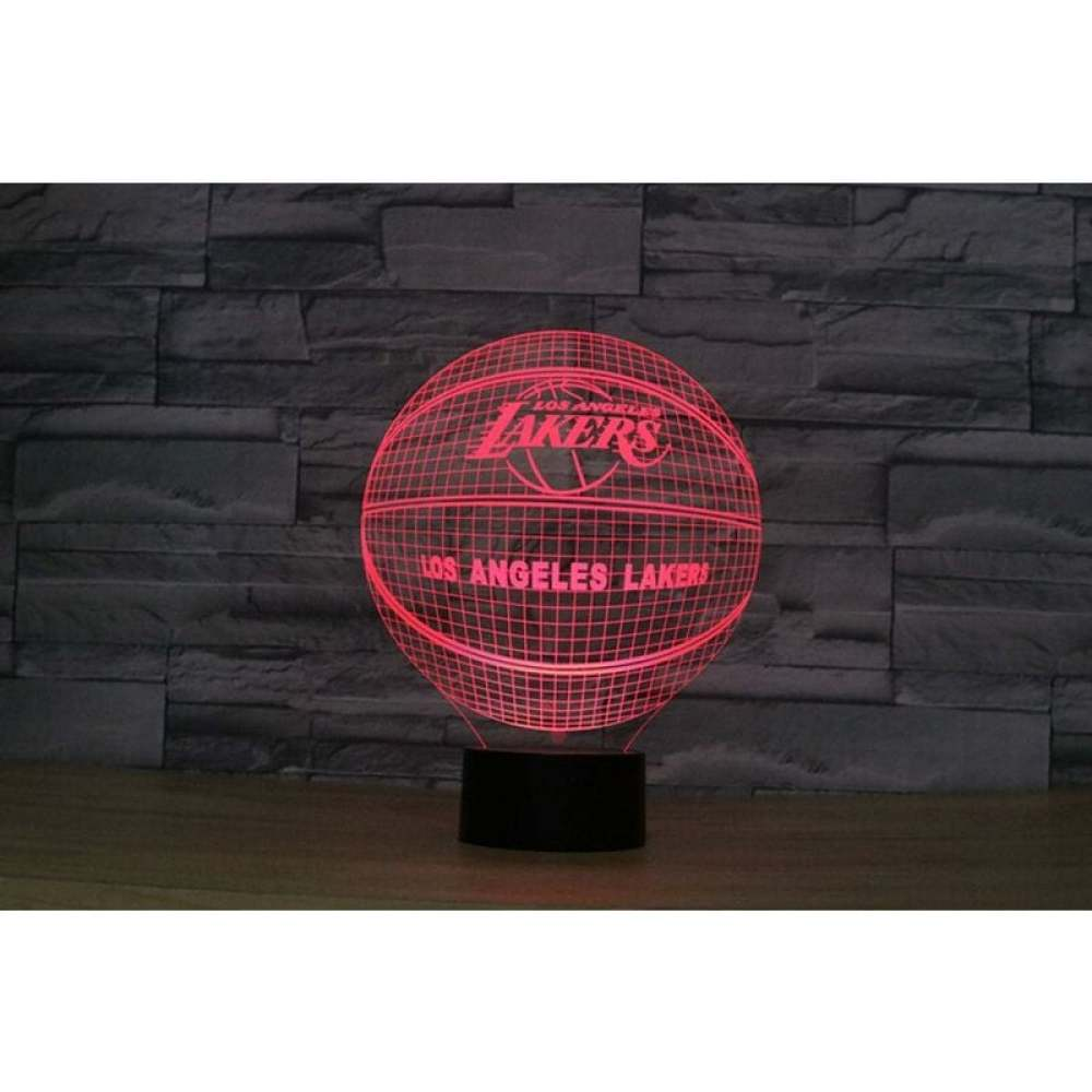 Eine rot leuchtende Basketballlampe mit Los Angeles Lakers Logo. Sie steht auf einem schwarzen Sockel vor einer dunklen Ziegelmauer.