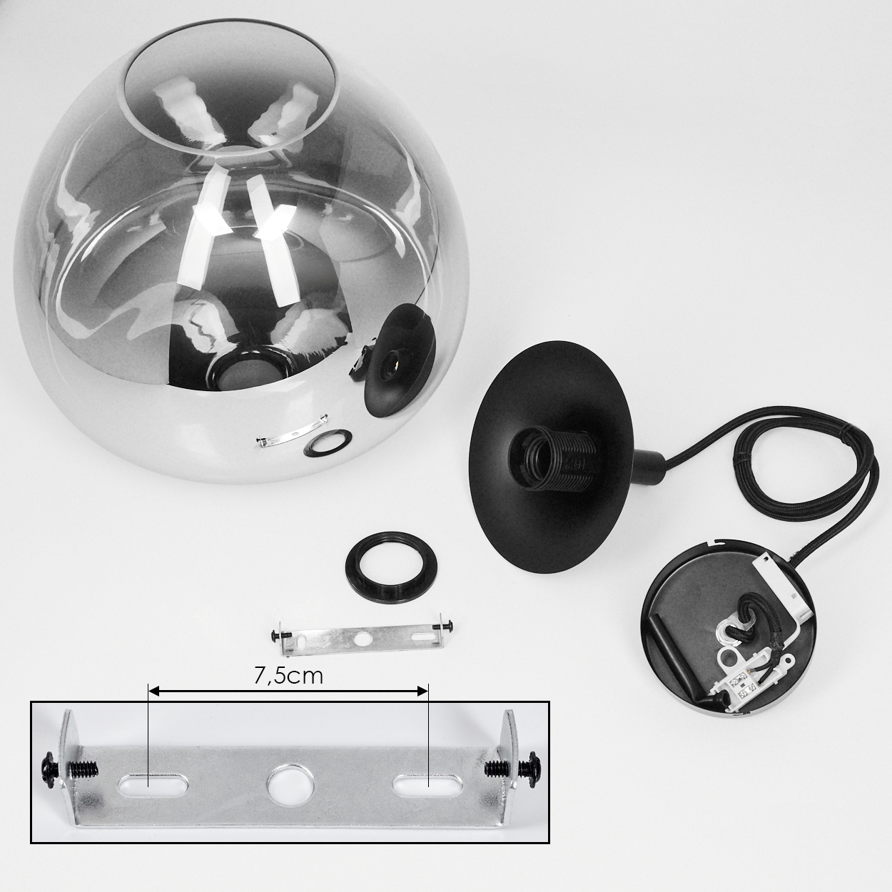 Eine zerlegte Lampe mit Glasschirm, schwarzen Teilen, Metallhalterung und Netzkabel. Teile sind auf einer weißen Oberfläche angeordnet.