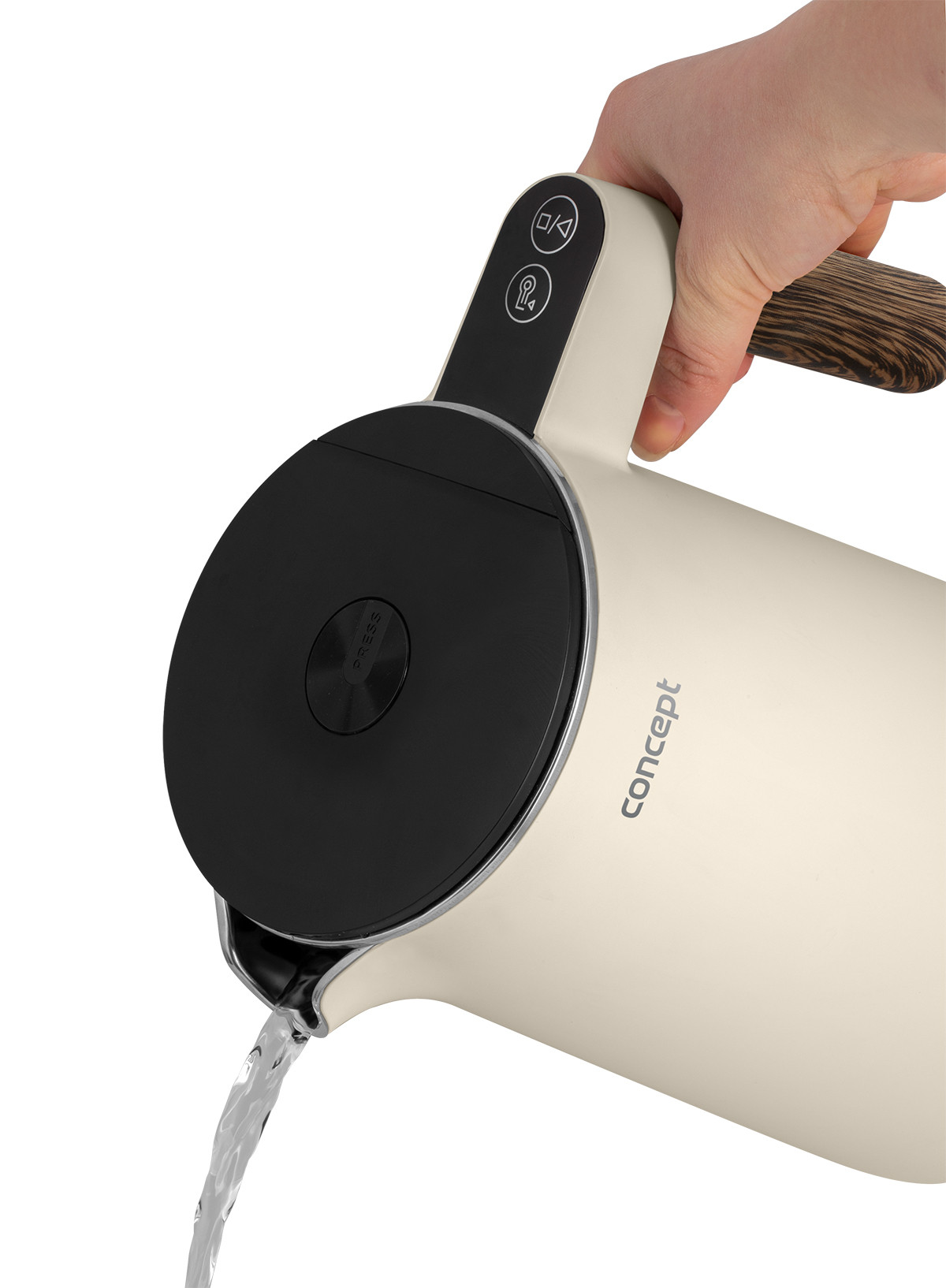 Kremowy czajnik elektryczny trzymany w dłoni. Woda wylewa się z dziobka. Uchwyt ma wzór słojów drewna.