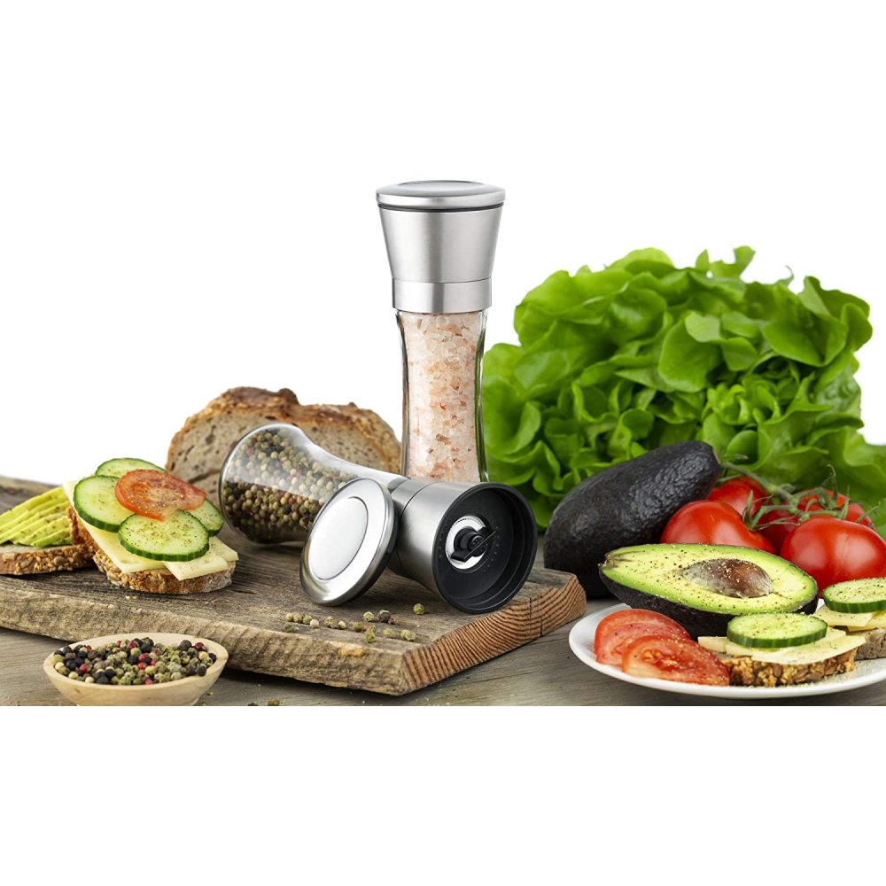 Ein Stillleben mit Sandwiches, Gemüse und Gewürzen. Enthält Avocados, Tomaten, Salat sowie Salz- und Pfeffermühlen.