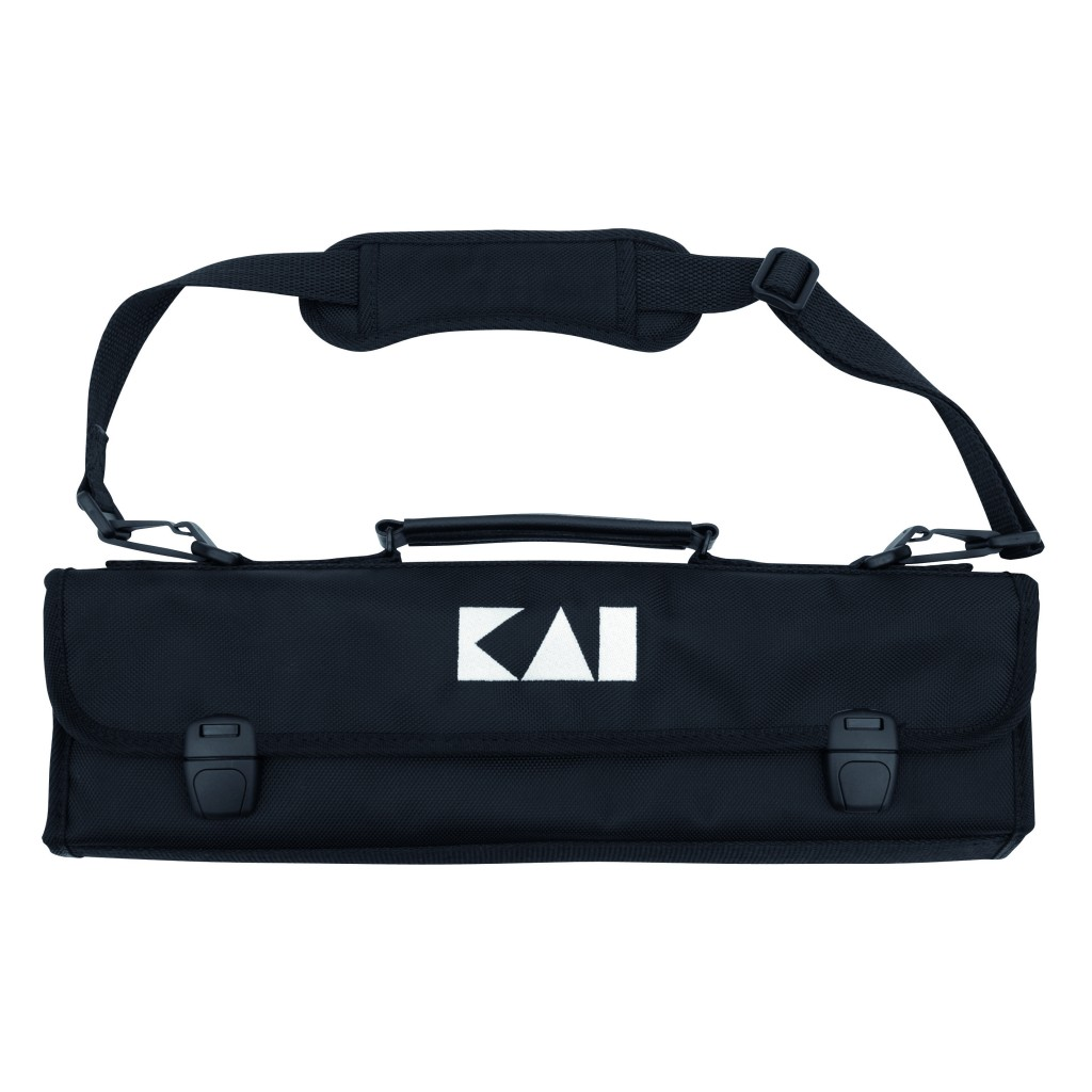 Eine schwarze Messertasche mit Schultergurt, Griff und weißem Logo. Zwei Verschlüsse sichern die Klappe. Die Tasche ist vor weißem Hintergrund.