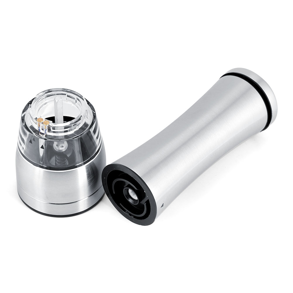 Eine zerlegte Pfeffermühle. Ein Teil ist ein Edelstahlzylinder, der andere hat einen klaren Deckel und eine schwarze Basis.