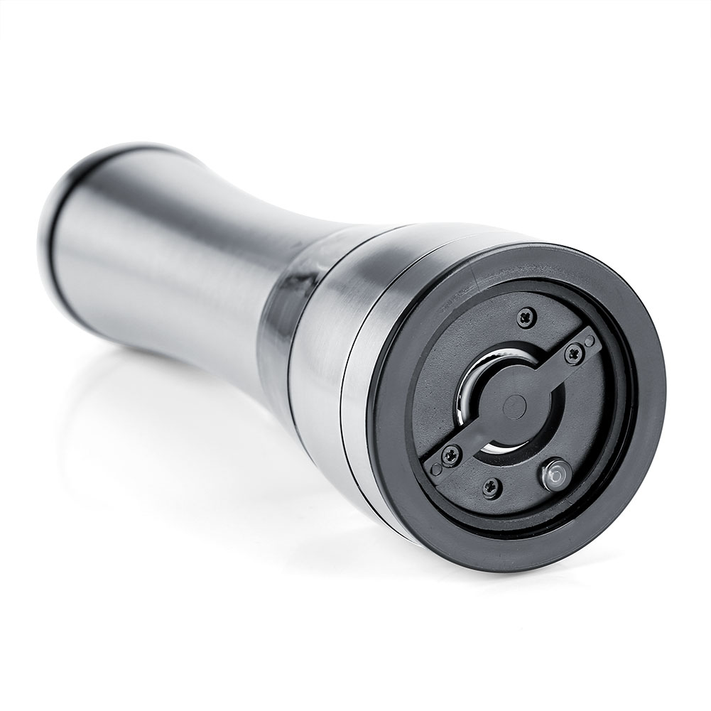 Eine metallische Pfeffermühle liegt auf einer weißen Oberfläche. Sie hat einen zylindrischen Körper mit einem schwarzen Mahlwerk an der Basis.