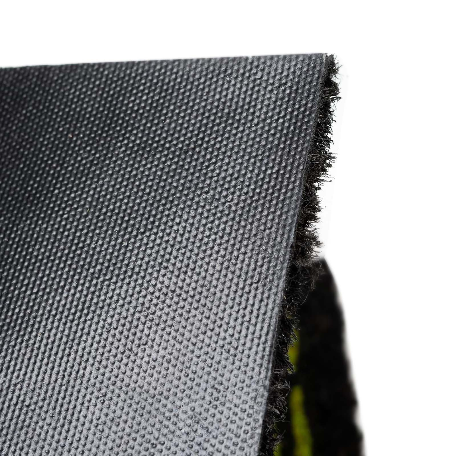 Primer plano de un material gris oscuro texturizado. El borde está deshilachado con fibras negras, sobre un fondo blanco.