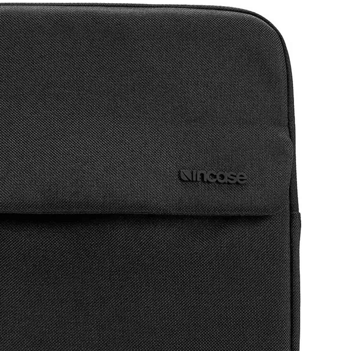Primo piano di una custodia nera per laptop. Il logo 'Incase' è visibile. La custodia è realizzata in un materiale strutturato e tessuto.