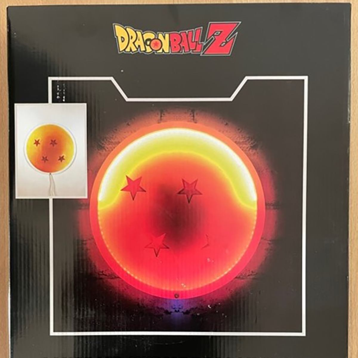 Eine Dragon Ball Z-Box zeigt eine rote Kugel mit vier Sternen. Sie leuchtet gelb. Das Dragon Ball Z-Logo ist oben.