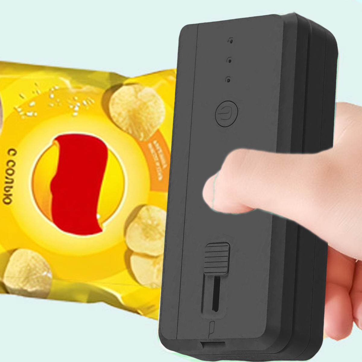 Eine Hand hält ein schwarzes Gerät. Im Hintergrund befindet sich eine Tüte Chips. Die Chips sind gelb und die Tüte ist gelb und rot.