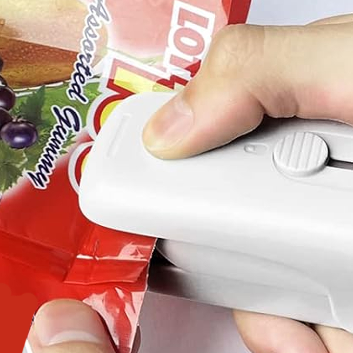 Eine Hand verschließt einen roten Beutel mit Gummibärchen mit einem weißen Versiegeler. Der Beutel hat Text und Bilder von Früchten.