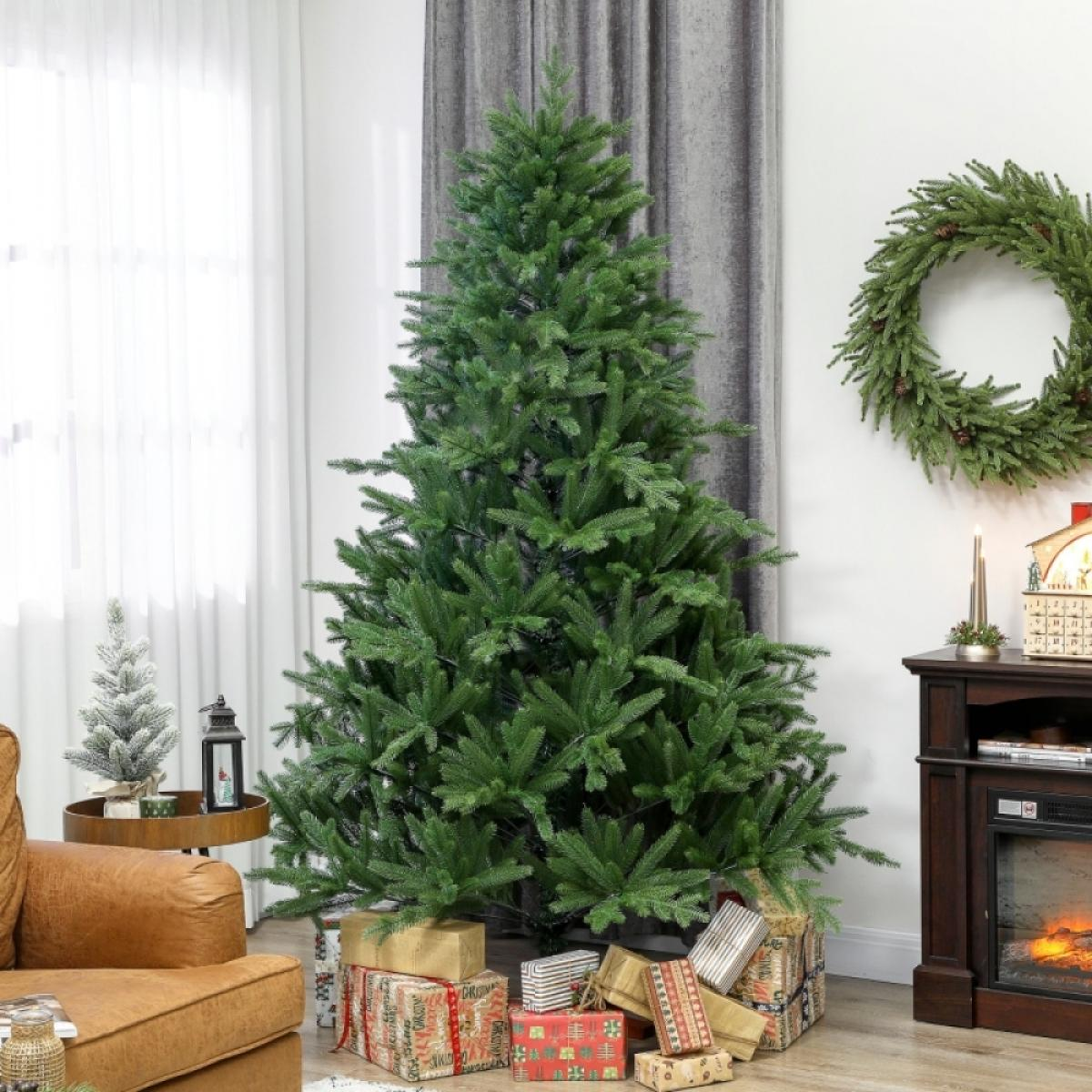 Ein geschmückter Weihnachtsbaum steht neben einem Kranz und Geschenken. Ein kleiner Baum und eine Laterne stehen auf einem Beistelltisch.