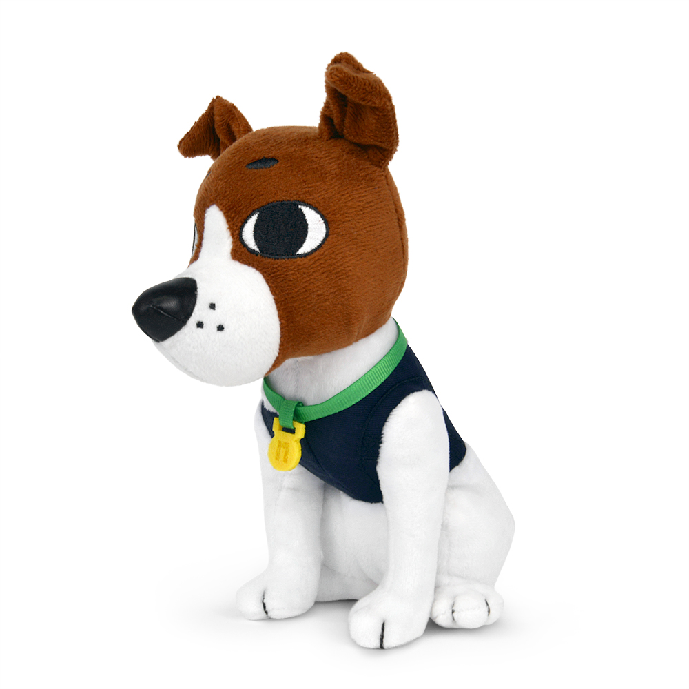 Ein Stoffhund sitzt. Er hat braunes und weißes Fell, eine schwarze Nase und trägt eine blaue Weste und ein grünes Halsband mit gelbem Anhänger.