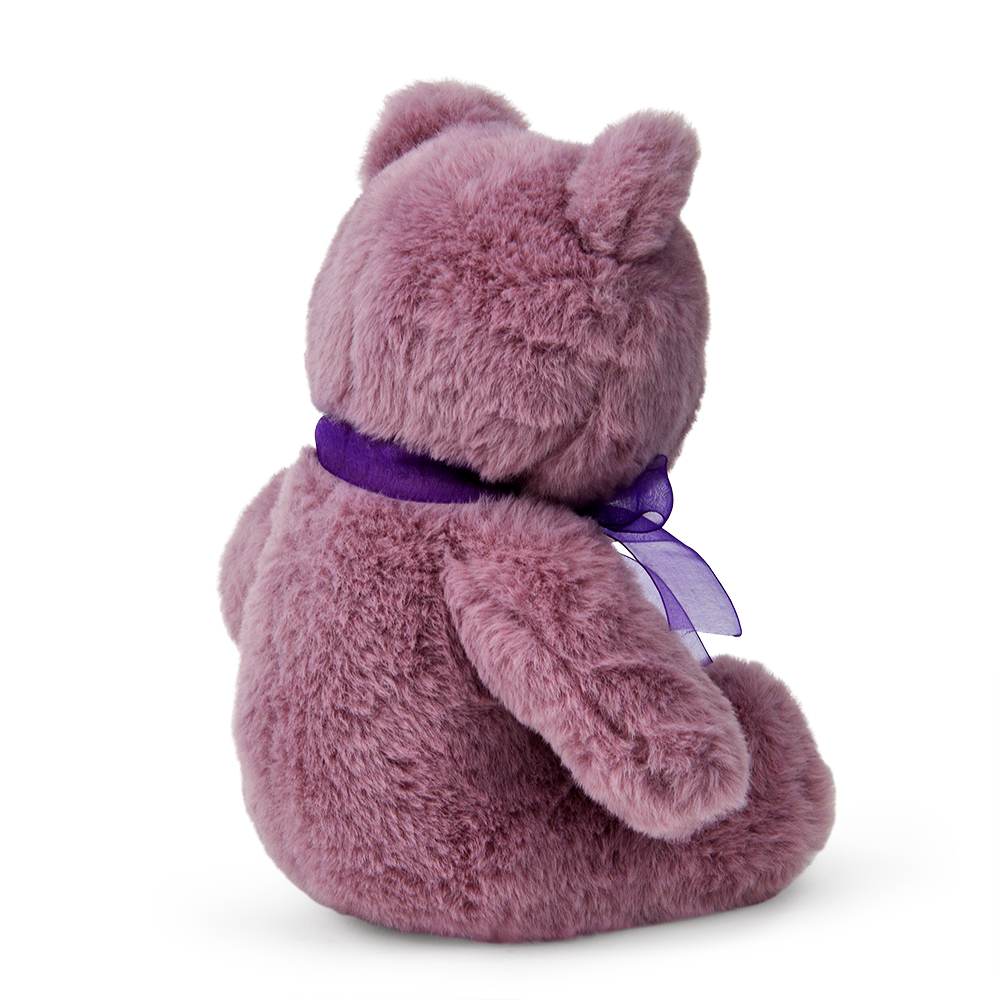 Ein rosa Teddybär sitzt abgewandt. Er trägt ein lila Band um den Hals. Der Bär befindet sich auf weißem Hintergrund.