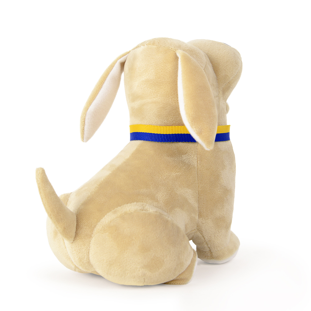 Ein beiger Stoffhund sitzt nach rechts. Er hat ein blau-gelbes Halsband. Seine Ohren sind lang und hängen herunter. Der Hintergrund ist weiß.